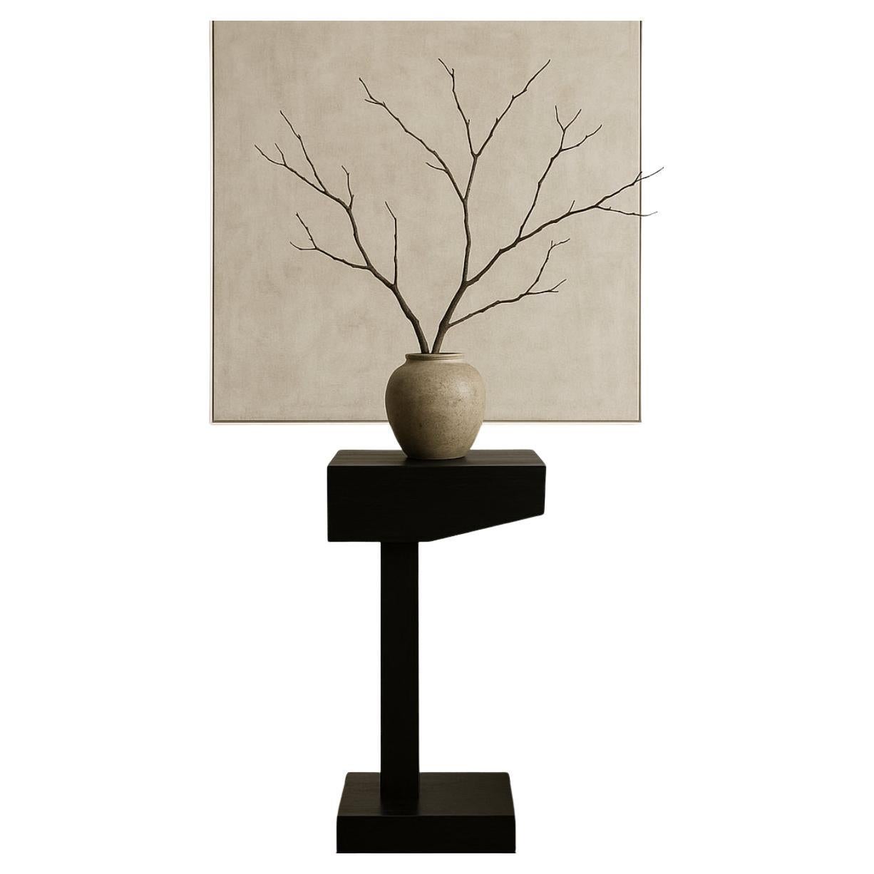 Tavolo con piedistallo in teak massiccio ebanizzato di Chista.  Can può essere utilizzato per esporre opere d'arte, manufatti, libri o luci.  Chista, fondata nel 1990, esplora le radici del primitivismo e del modernismo, il trovato e la scultura nel