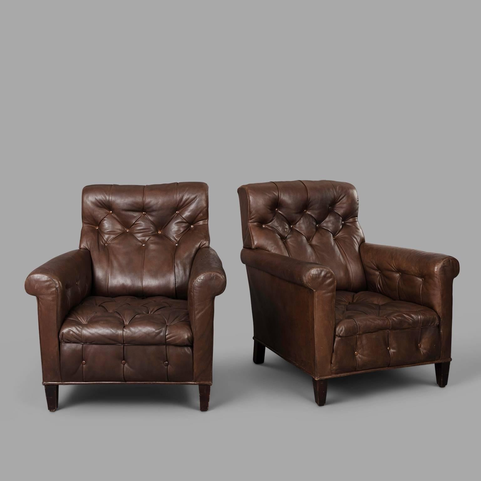 Leather patina highly enhanced by the time for this pair of early 20th century tufted leather armchairs.

Few expert restorations to strengthen the leather.