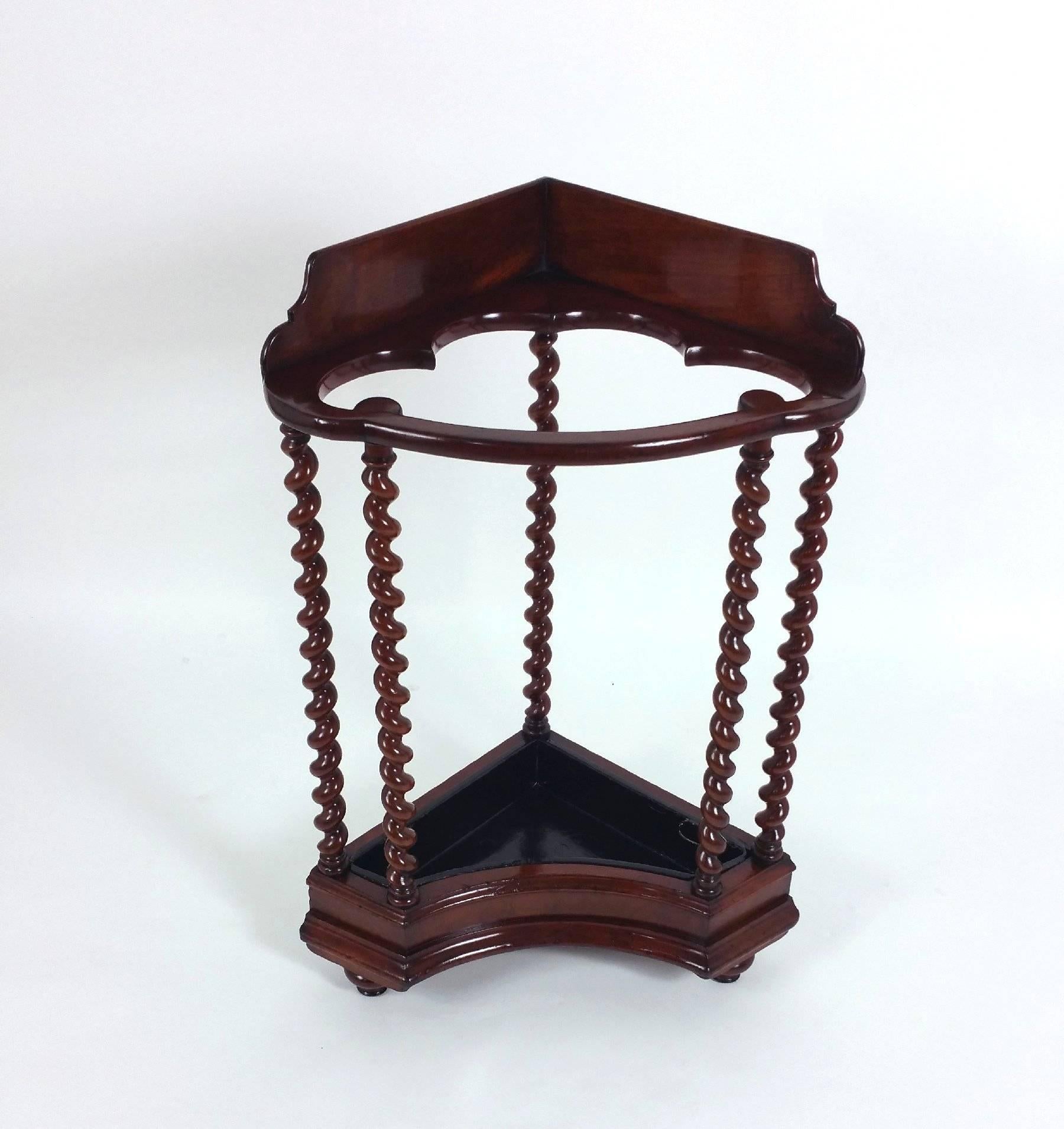 This very unusual and stylish-looking Victorian walnut corner stick or umbrella stand features a three quarter gallery with barley twist supports and a removable metal drip tray. It measures 23 in – 58.4 cm wide, 17 ½ in – 44.5 cm deep and 34 in –