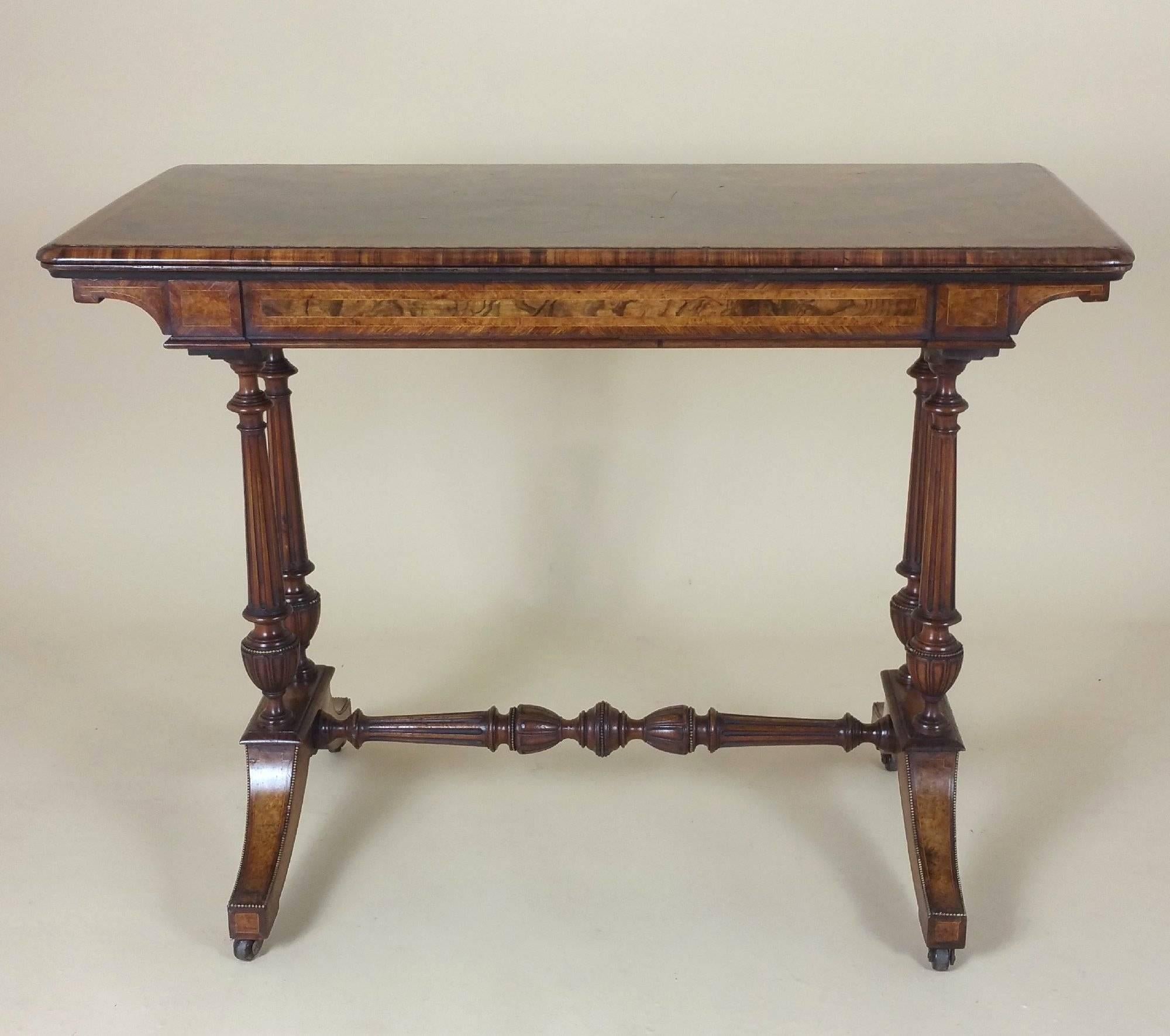 This beautiful 19th C. figured walnut fold over card table is stamped Lamb of Manchester, a well-known and prominent cabinet maker of the period. The card table features a cross banded decoration of Amboyna and brass mounts, with lovely detail work