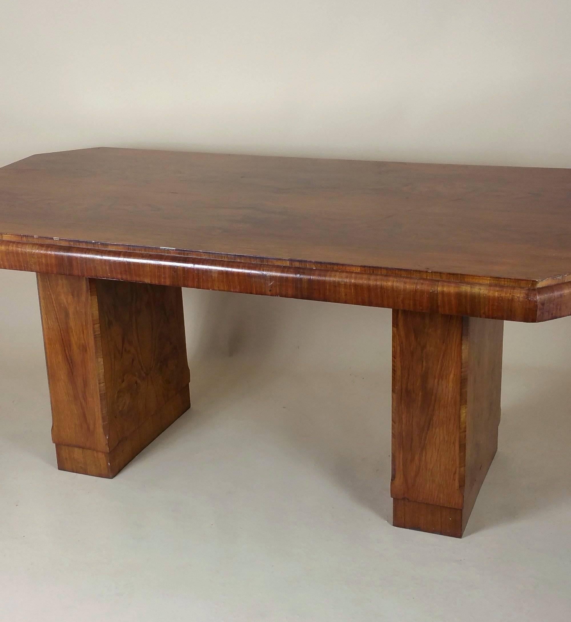 This beautiful and substantial Art Deco dining table showcases a Classic style of the period. The table has an oblong hexagonal shaped top and stands on twin slender pedestal supports. The table measures 74 in – 188 cm wide, 38 in – 96.5 cm deep and