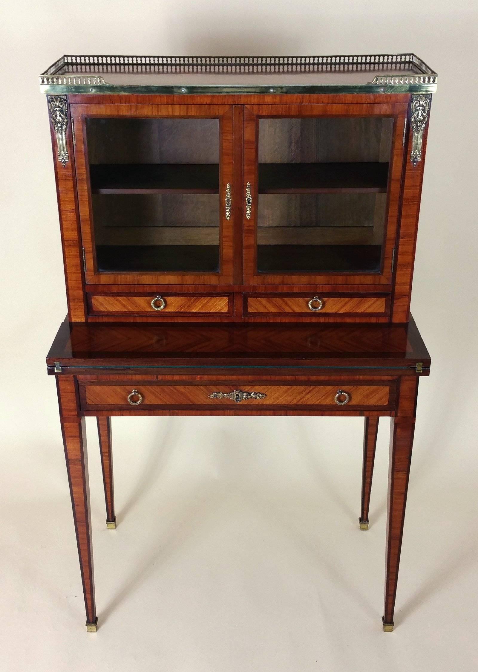 This exquisite and elegant French kingwood and mahogany Bonheur Du Jour, or ‘daytime delight’ is a type of lady’s writing desk and features detailed ormolu mounts, a pierced gallery around the top and long tapered square legs with brass caps. The