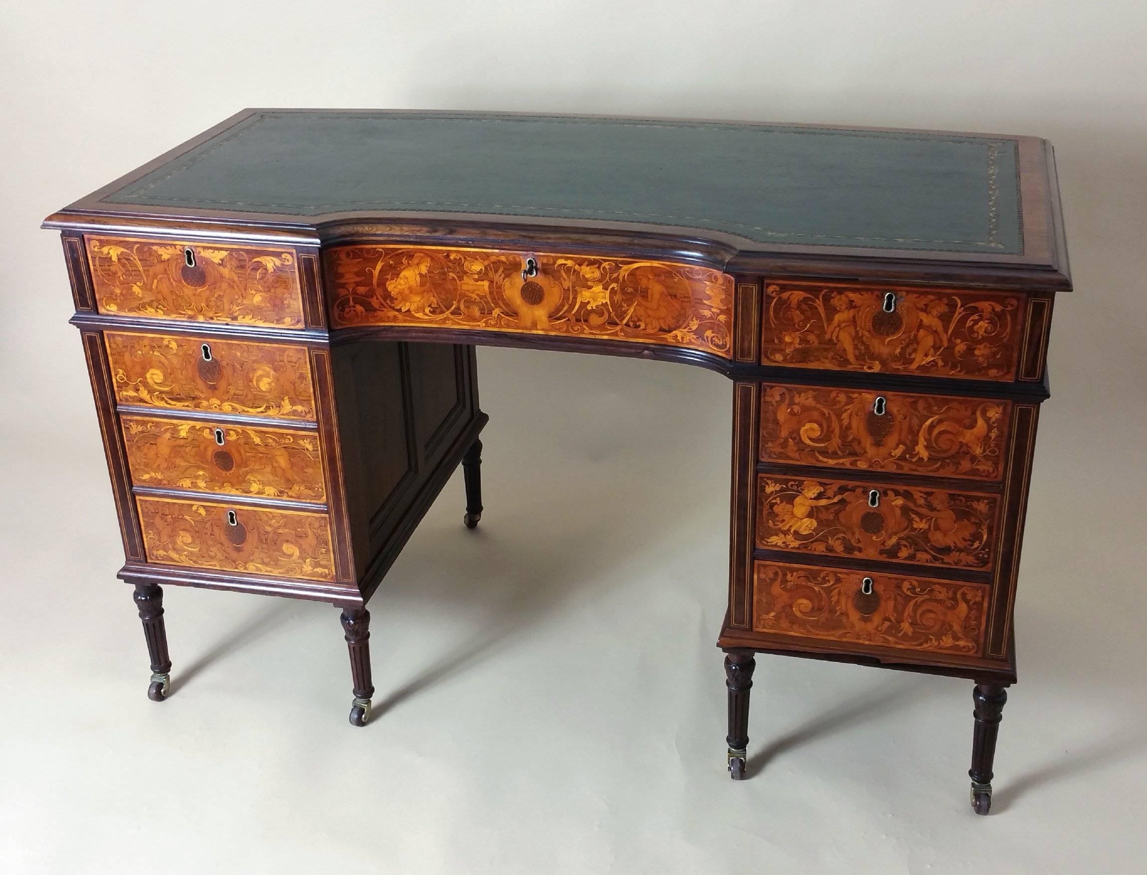 This magnificent Victorian marquetry inlaid rosewood kneehole desk features a shaped front and concave back, inlaid with satinwood, boxwood and palm wood, depicting cherubs and heavy scrollwork. The profuse and ornate inlay work is well executed,