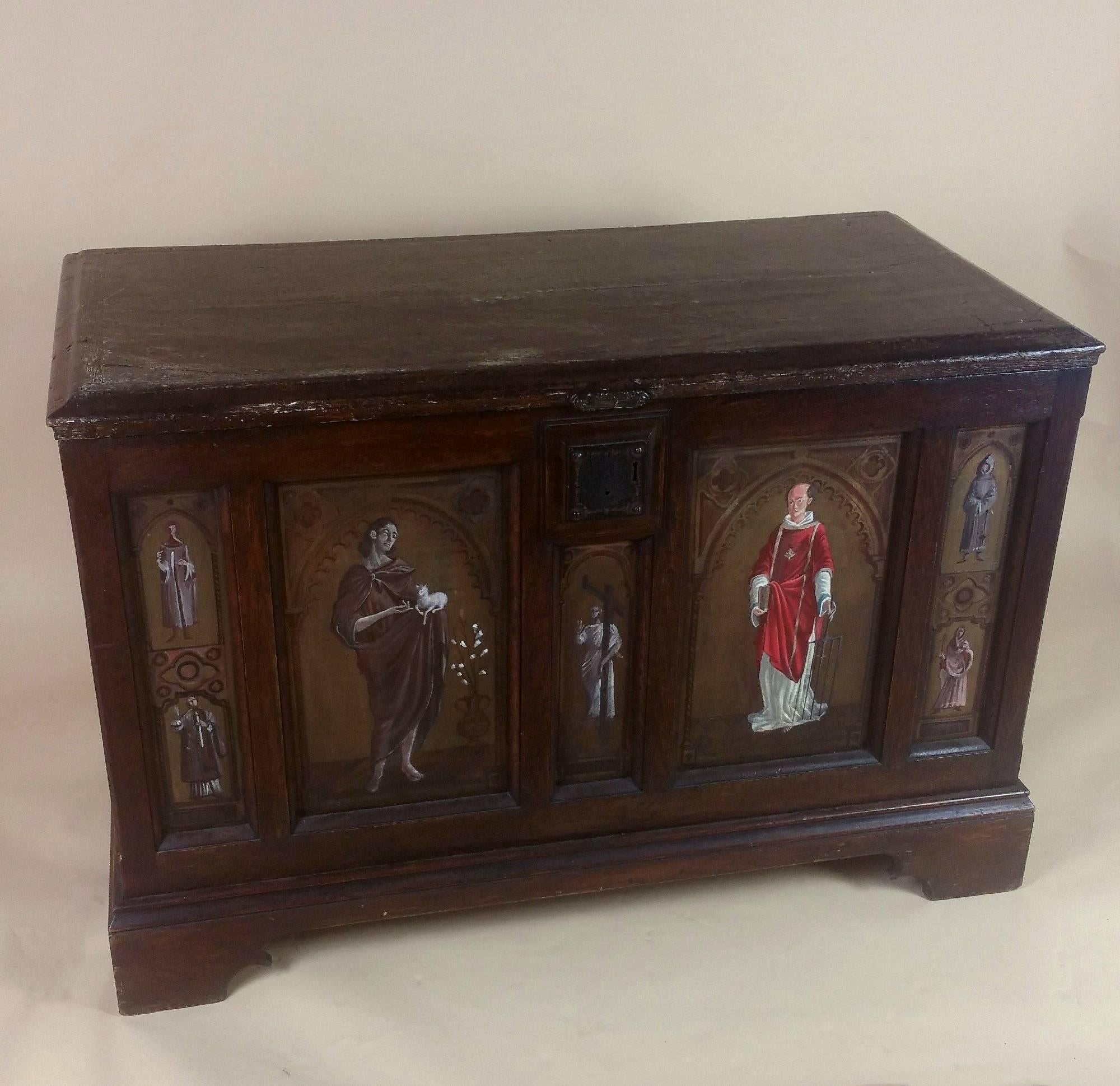 This striking and highly decorative 19th C. French oak and Chestnut coffer features a series of hand painted  Saints and portrait figures on the front and both sides, with a religious scene painted on the back. This beautiful and ecclesiastic