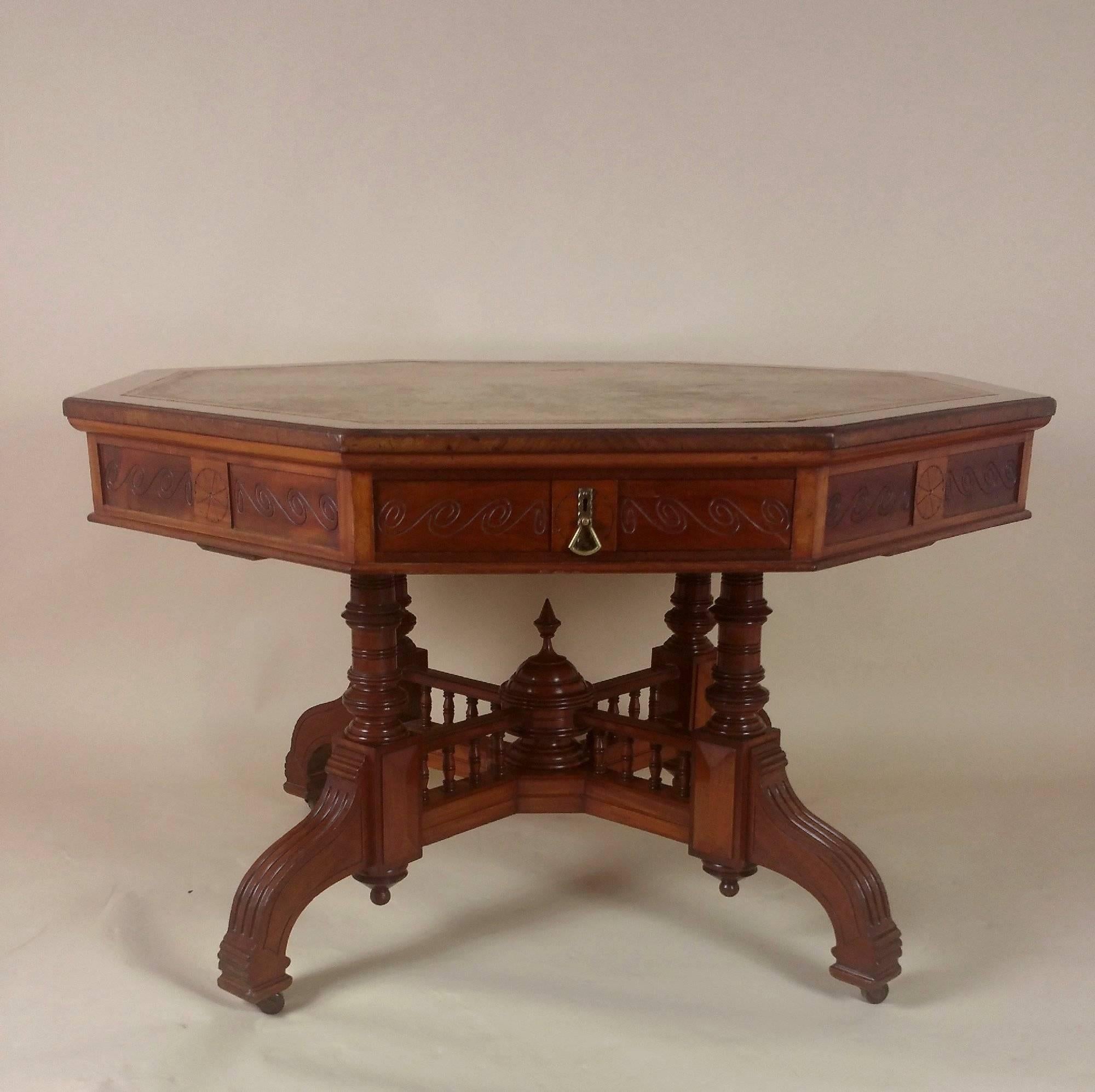 This excellent quality Victorian walnut octagonal Arts and Crafts library table features the original leather top and is stamped Maple and Co., a well-known and highly regarded cabinet maker of the period. The table is supported on an elaborately