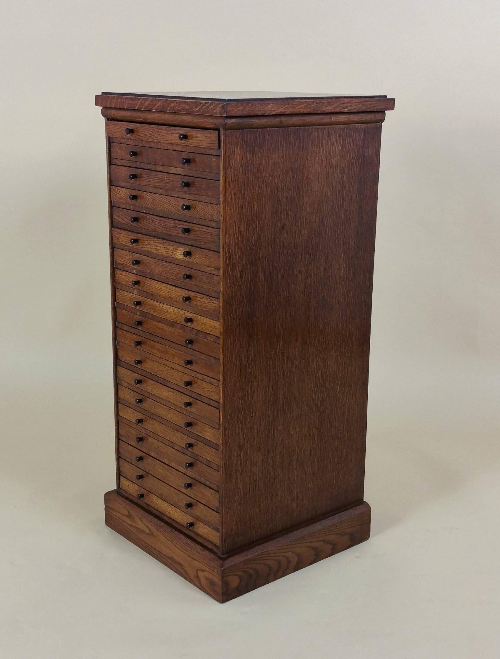 This superb quality and unique collector’s chest features 19 drawers, several of which have coin hole insets. The chest is English and made of oak, with a beautiful rich and warm patina. It measures 14 in – 35.5 cm wide and deep, with a height of 31