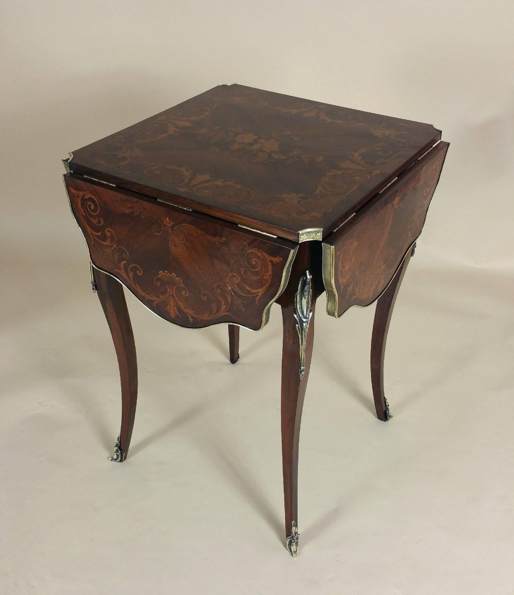 This magnificent late 19th century French marquetry rosewood centre table features an intricate inlaid design of scrolls and floral patterns in olivewood and satinwood. The table has four folding shaped sides, with a brass rim border and ornate