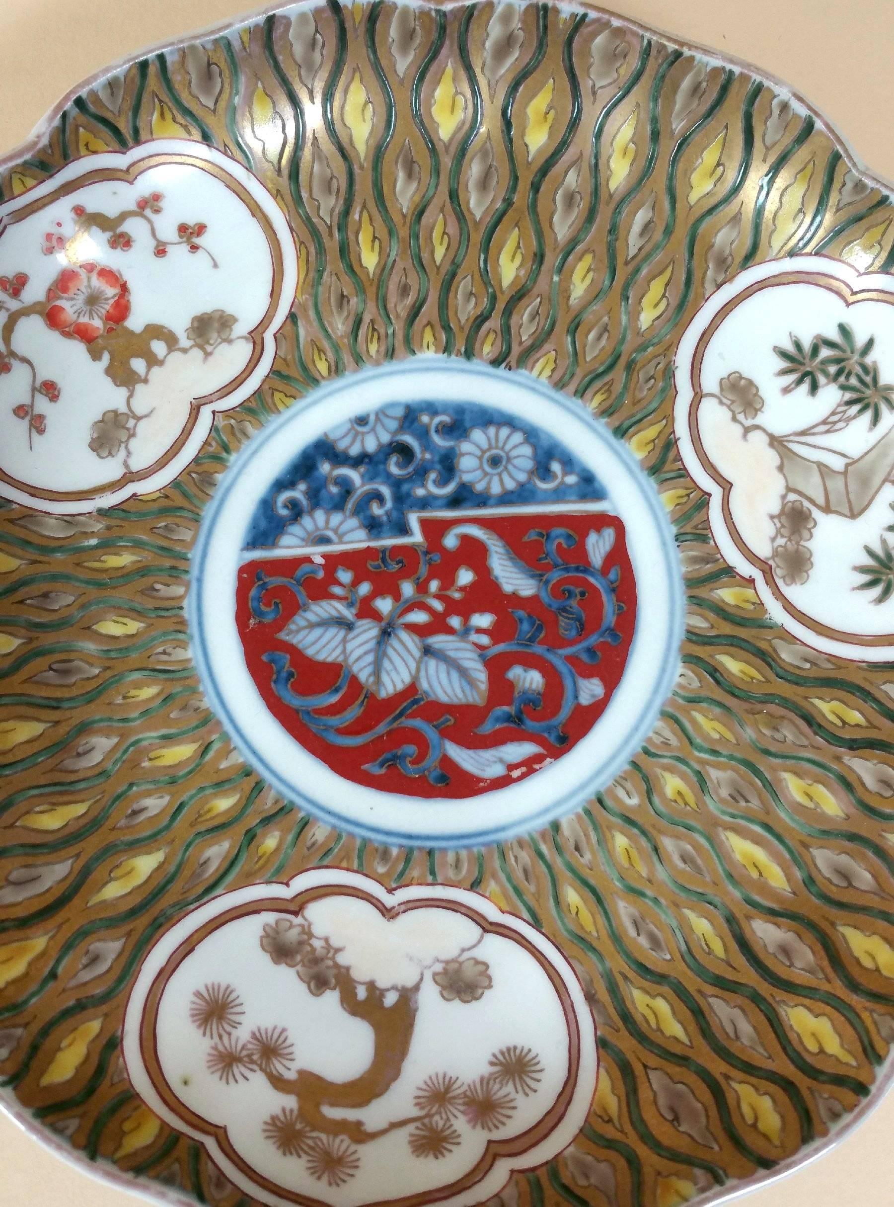 A fine Japanese Korancha lobed pottery dish painted in enamels depicting flowers, bamboo and a profuse design of gilt leaves and patterns. The dish has a Korancha blossom mark on the underside bottom of the dish with floras and scroll work along the