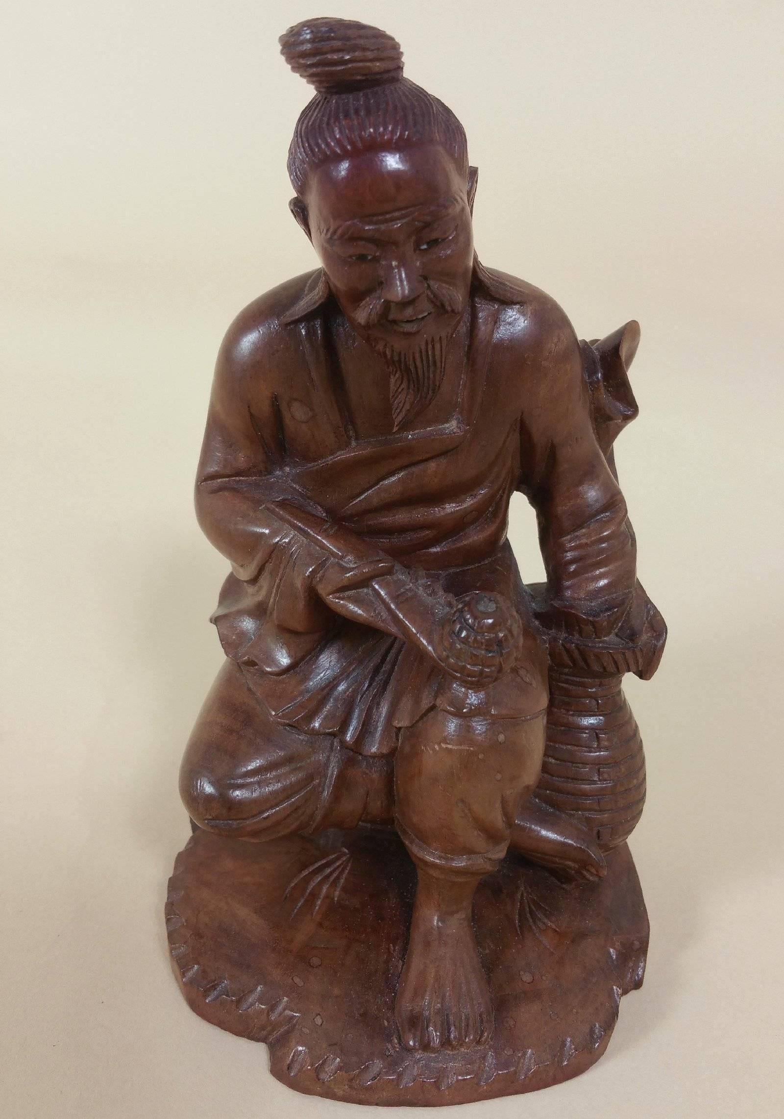This marvelous and very tactile Japanese fruitwood carving is of a gentleman smoking a pipe. The statue stands on a square hardwood carved base topped with red velvet. The detailing is crisp and the wood shows natural markings and wear on the back,