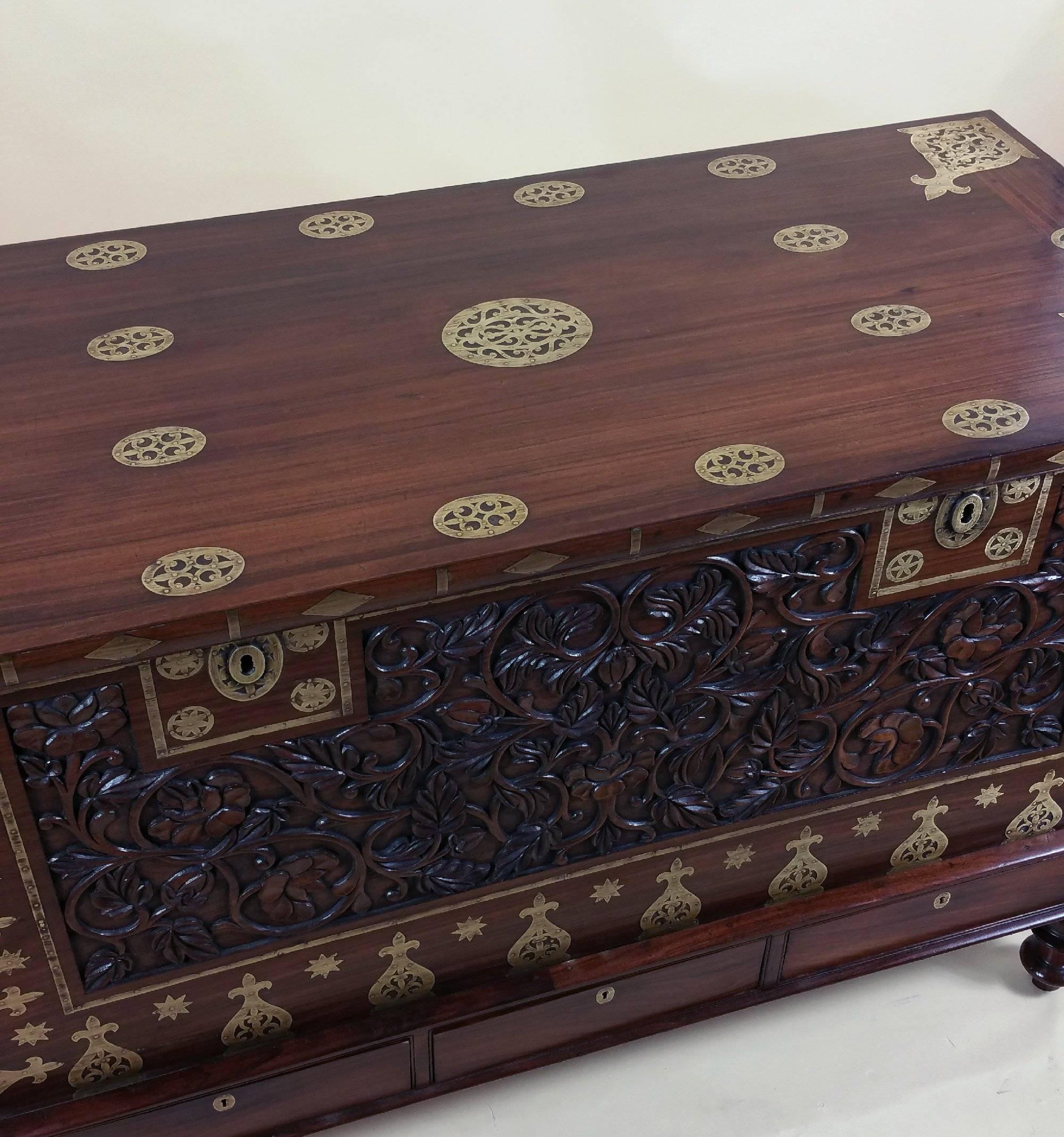 This superb zanzibar teak intricately carved chest features ornate brass mounts and three drawers to the base, with a key to the front and drawers. This beautifully designed chest features a series of inset brass medallions and patterns, with a