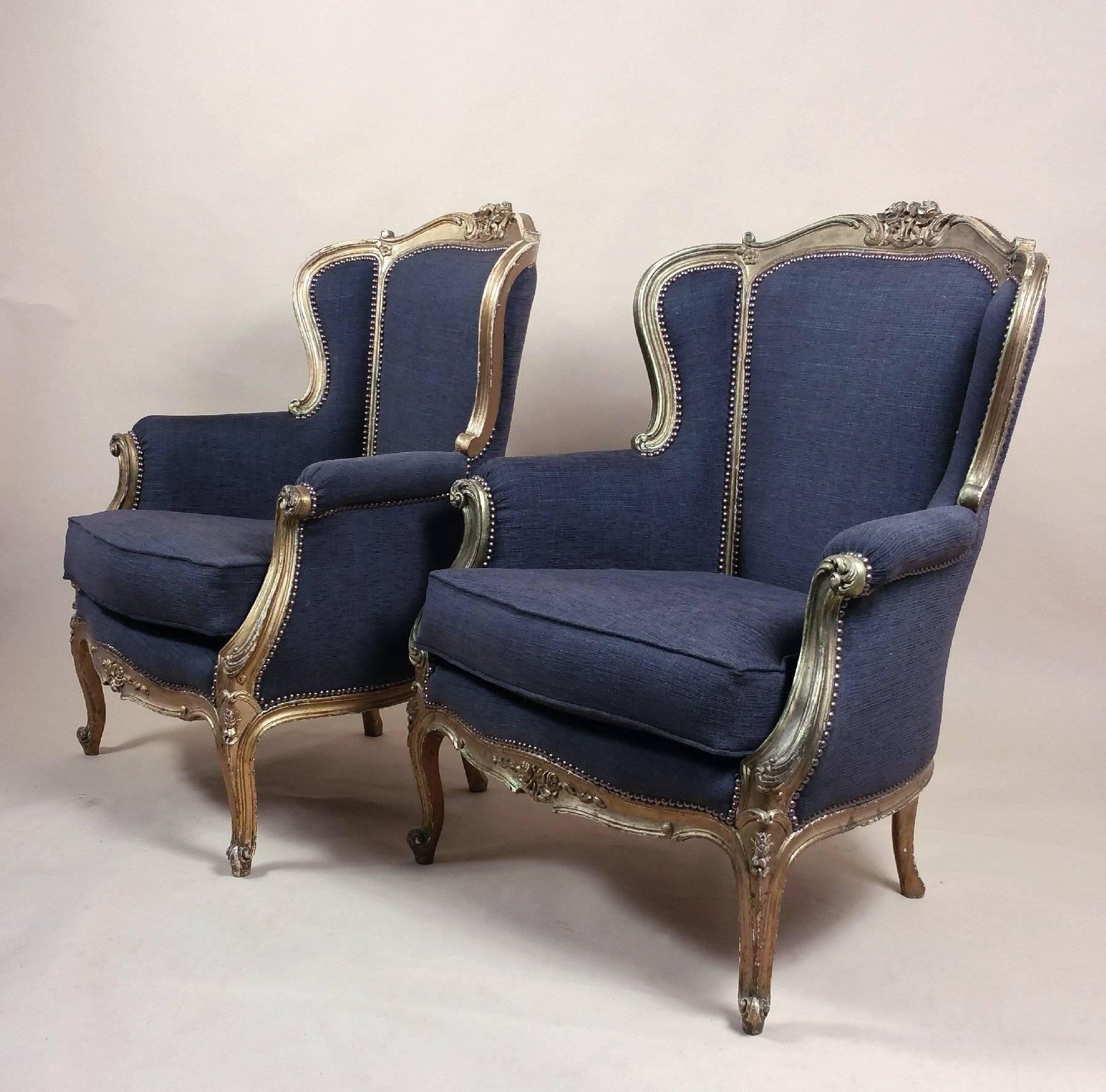 This gorgeous pair of late 29th century French carved giltwood framed armchairs are upholstered in a sumptuous charcoal colored woven fabric by Ross Kenton. Beautifully shaped and superb quality, they are not only very comfortable to sit in but make