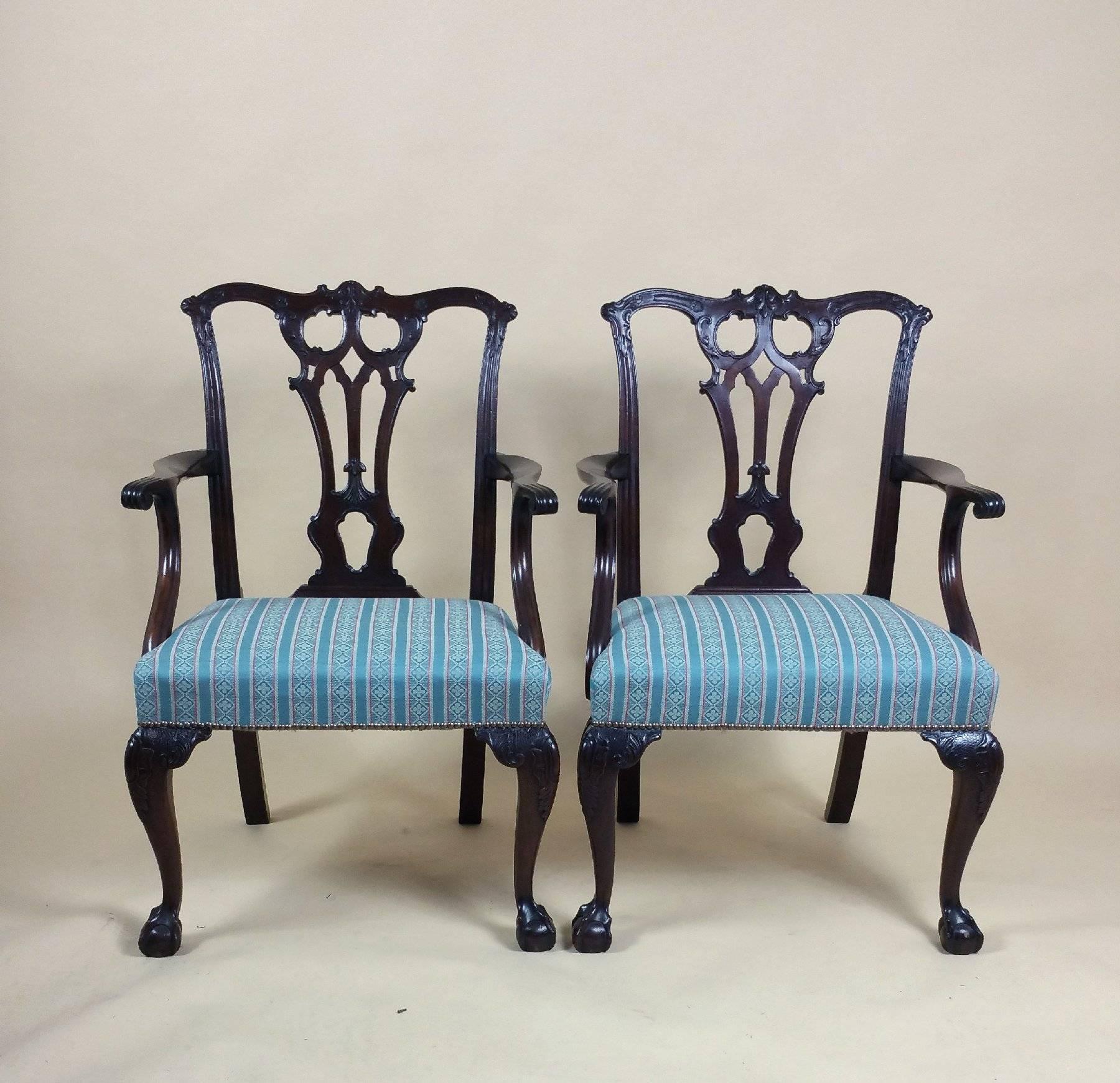 This superb and elegant pair of 18th century English Chippendale carved mahogany elbow chairs Stand on swept back and cabriole front legs with ball and claw feet. The chairs have a lovely pierced back carved with ‘C’ scrolls and acanthus leaves, as