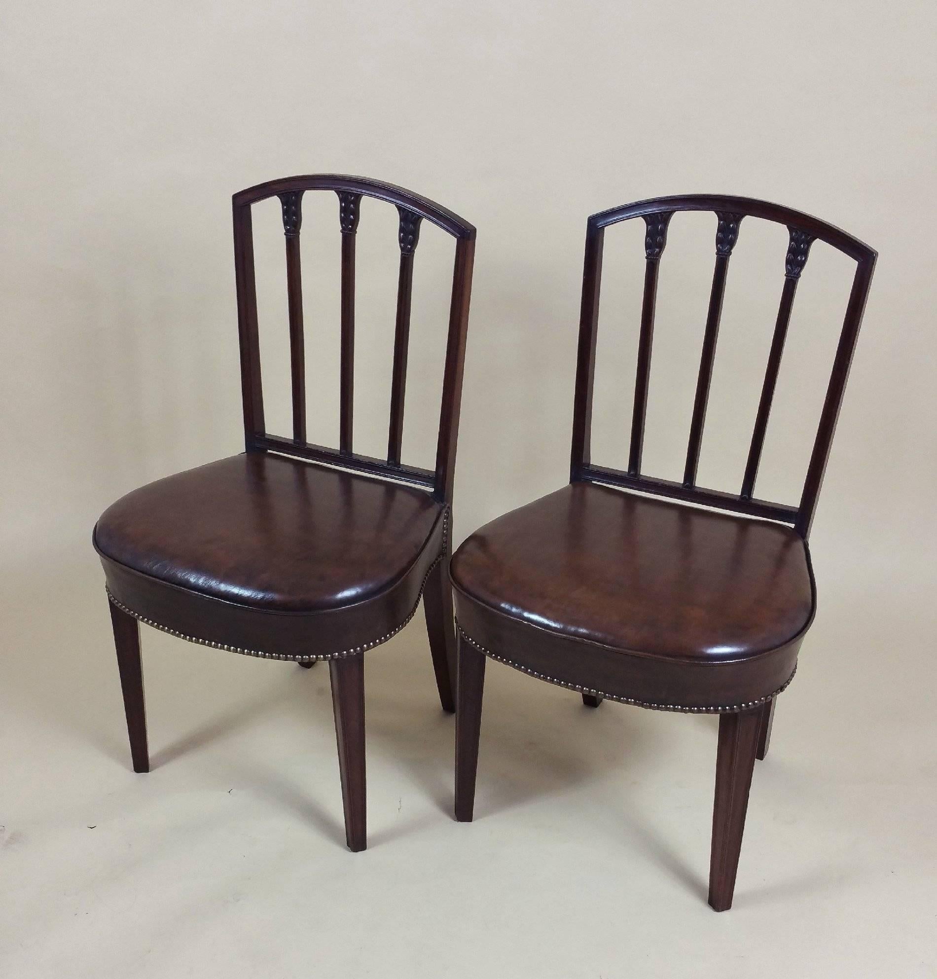 This splendid and rare set of ten English mahogany 18th century. Sheraton dining chairs feature delicately carved honeysuckle on the back splats and very comfortable hide shaped leather seats with brass stud trim. Each chair measures 20 ½ in – 52 cm