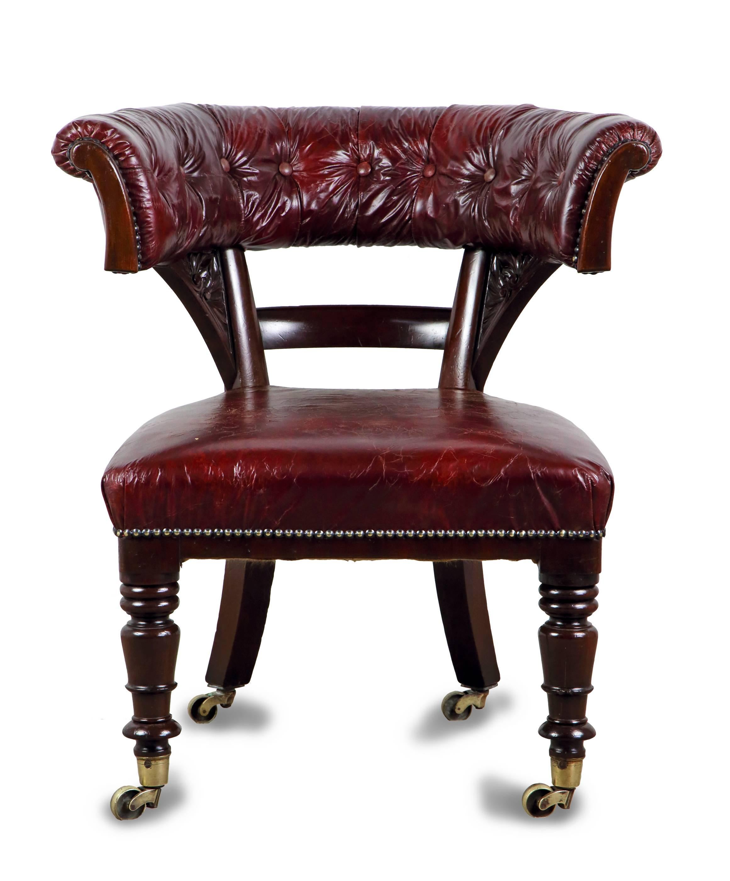 A handsome, generously proportioned, and superb quality mid-19th century period mahogany and leather upholstered gentleman’s desk or library chair, having a ‘horseshoe’ shaped button upholstered back, above a plain bar splat flanked by uprights with