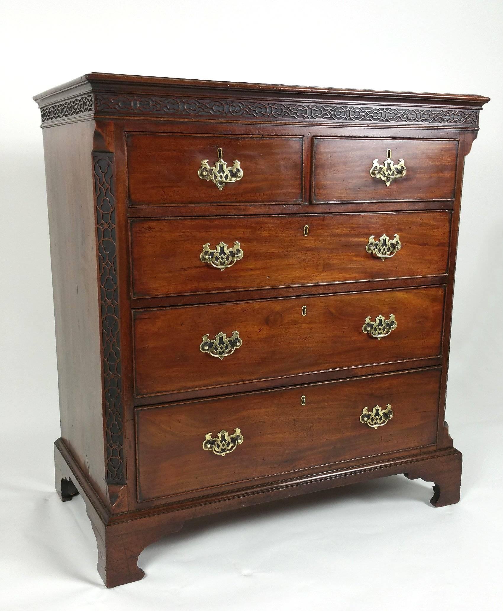 This marvelous 18th century Chippendale mahogany chest features two short over three long slightly graduating drawers with blind fret decoration around the top and along both front sides. The chest stands on bracket feet and is designed with canted