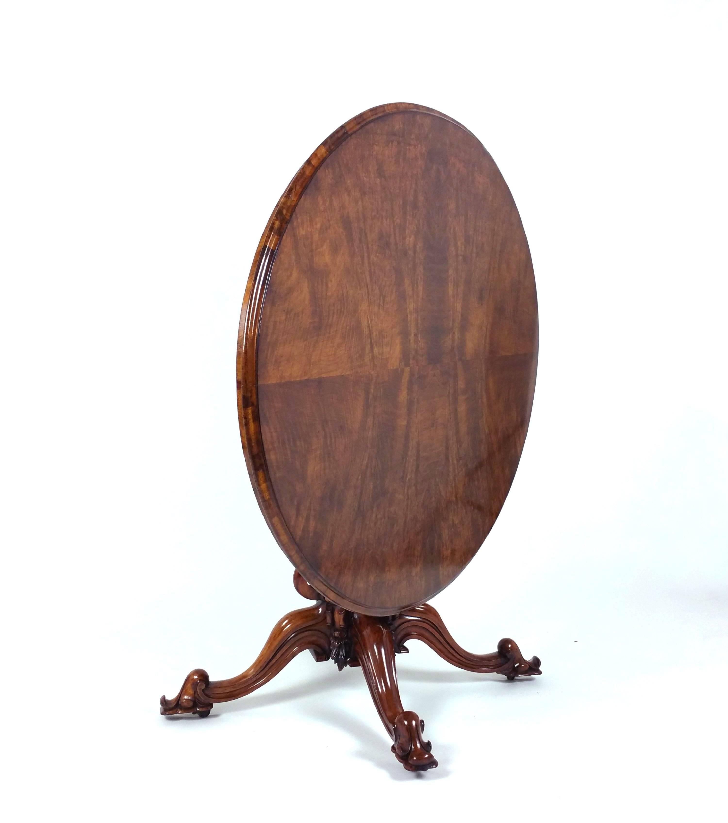 This well-proportioned and stunning early Victorian figured walnut oval center table features a tilt-top design on a very ornately carved and pierced Quadra form base. It measures 58 in – 147.3 cm wide by 43 in – 109.2 cm deep with a height of 28 ¼