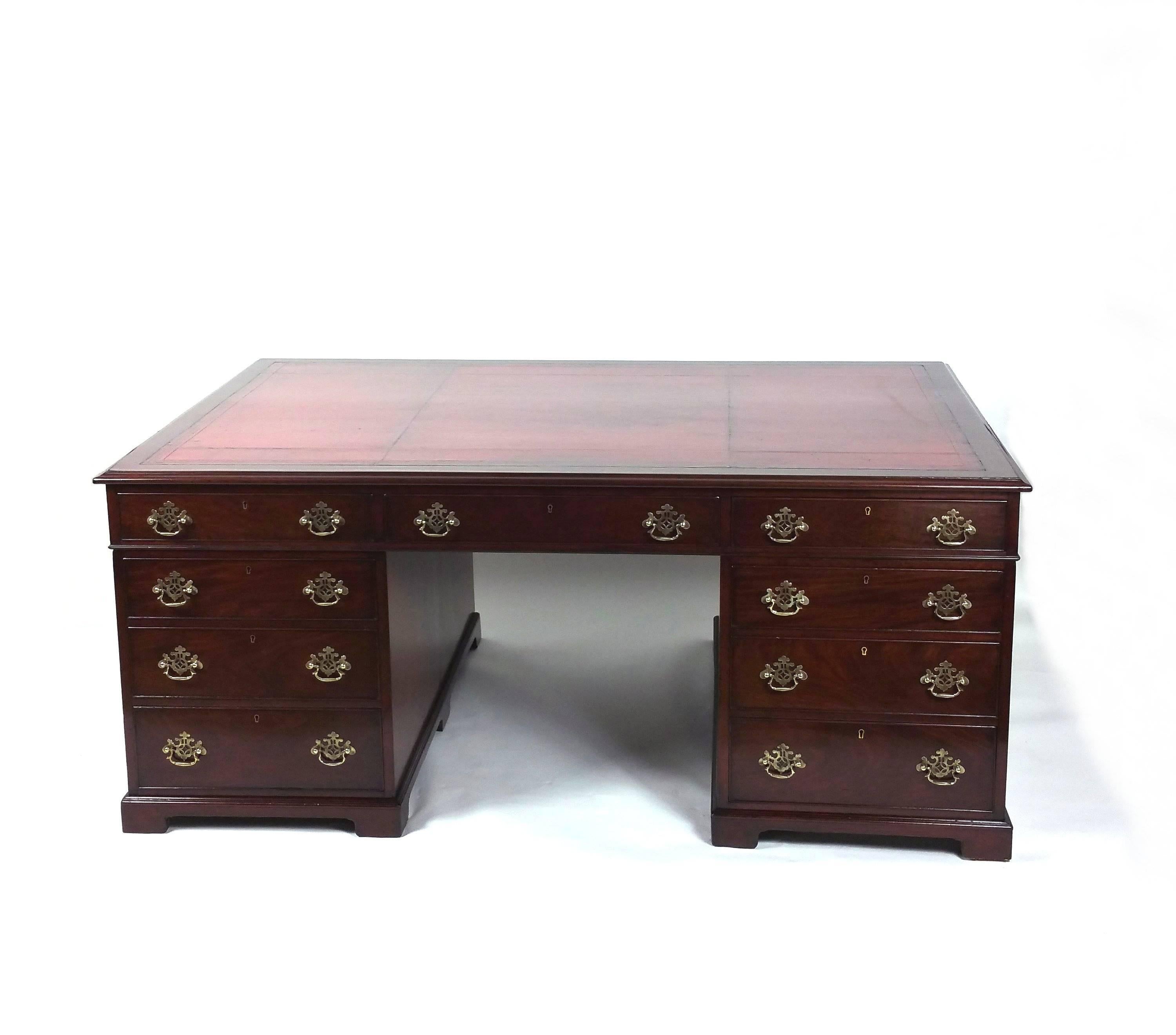 This magnificent and impressively large Victorian partners desk is stamped Phillips of Bristol, a fine cabinet maker of the period, and features the original tooled red leather top. The desk has nine drawers on the one side and three drawers over