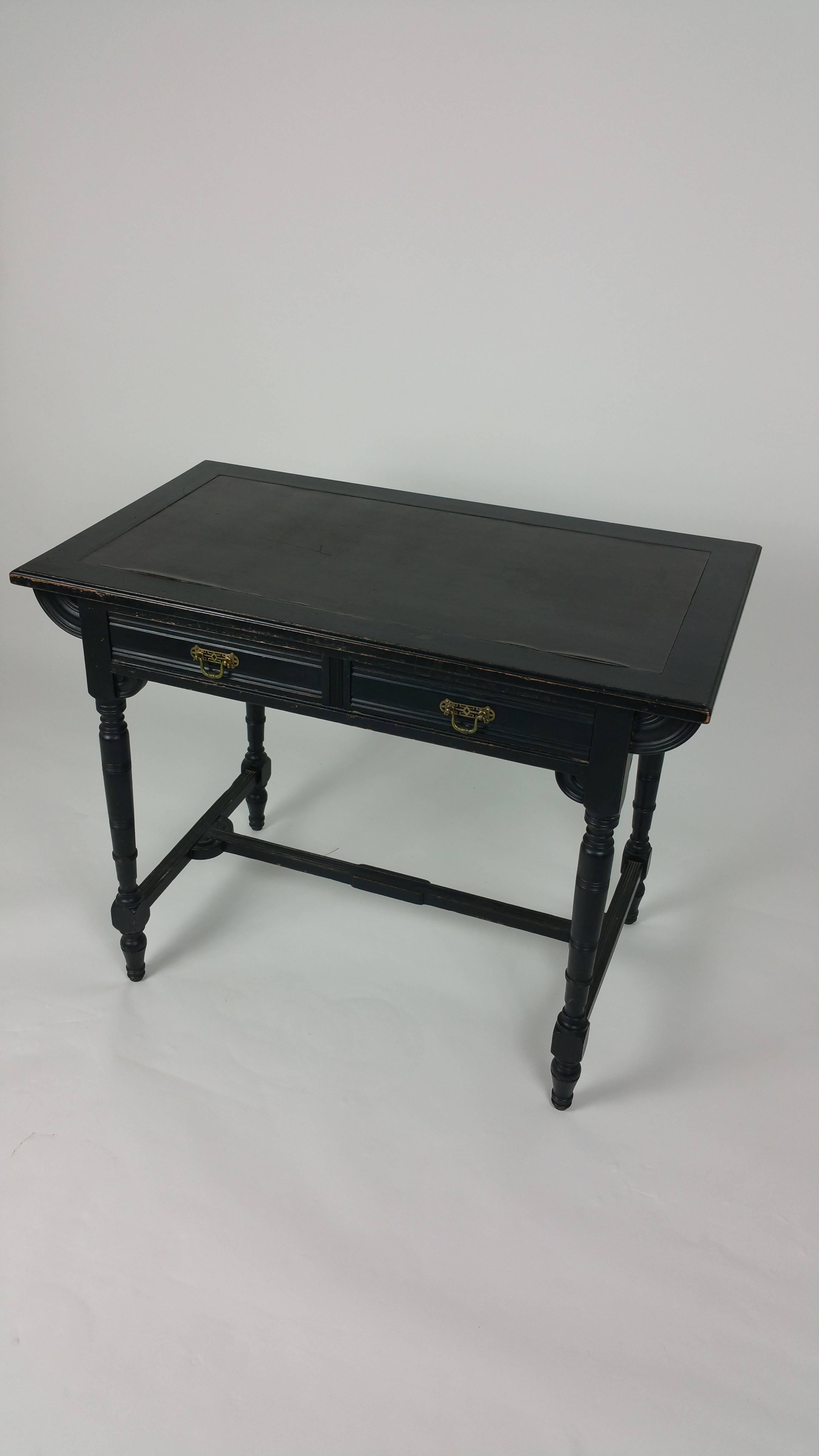 This marvelous and well-proportioned 19th century Art & Crafts Aesthetic movement ebonized mahogany writing table features two slender top drawers with the original brass handles and original condition throughout. It measures 36 in – 91.5 cm wide,