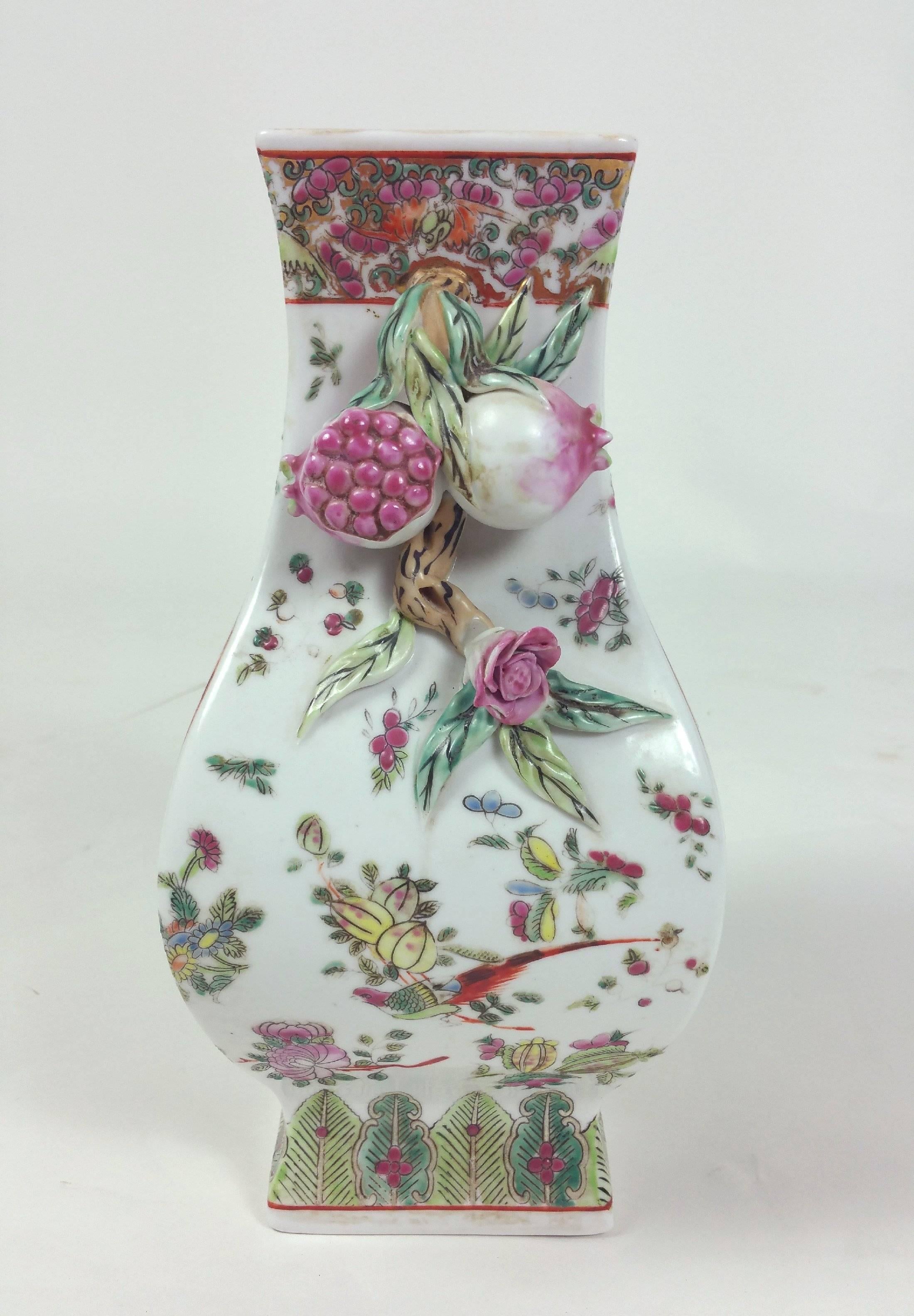 This beautiful and ornately designed early 20th century Chinese shaped vase features twin handles with lovely detailed relief work of fruit and foliage. The hand-painted detailed design features exotic birds with flowering trees and a seal mark to