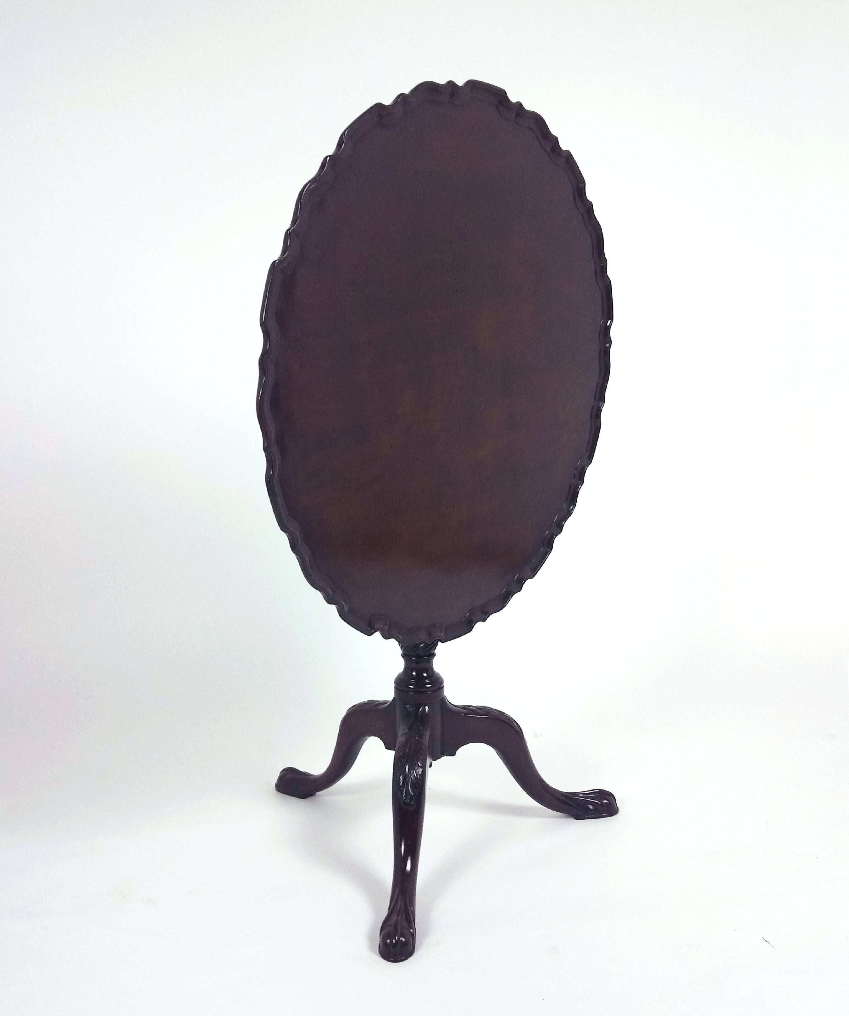 This superb quality mahogany tilt-top tripod table features a single piece top with a beautifully carved pie crust edge. The table has a twist turned stem with slender ball and claw feet, carved with acanthus leaf detailing. The table is bit larger