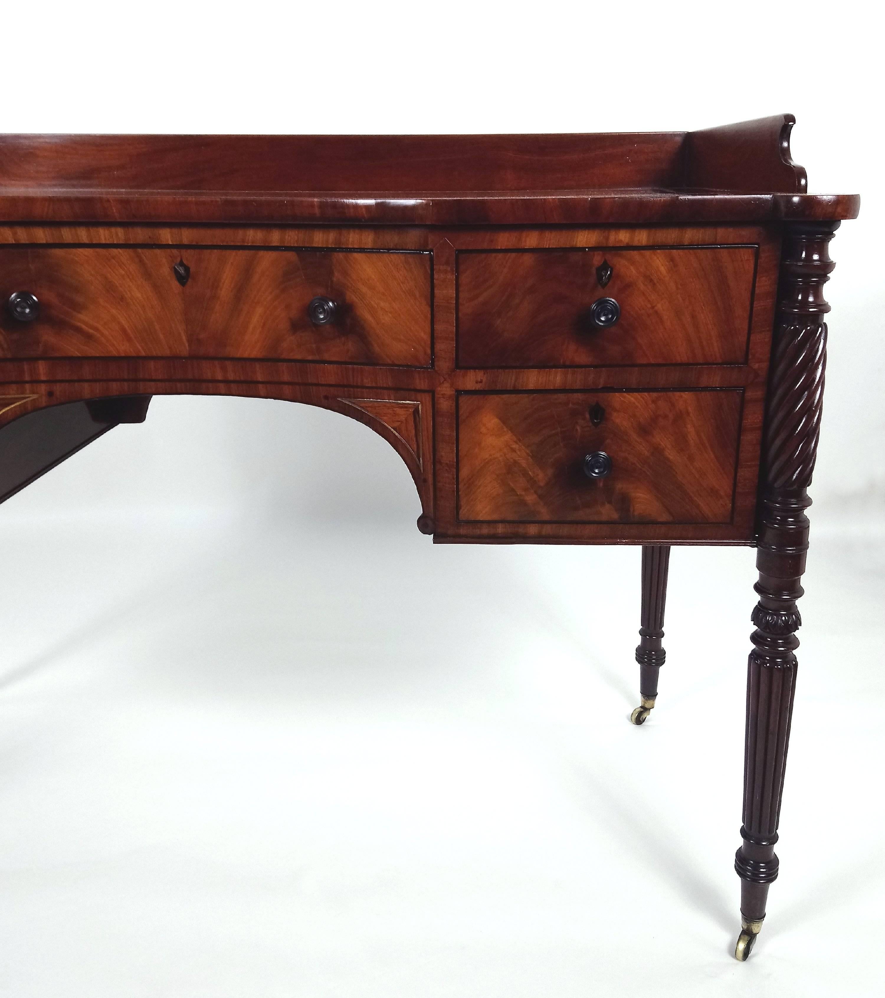 This fine quality and handsome late Regency figured mahogany knee-hole sideboard features a central drawer with two drawers to each side. The side table has a concave shaped knee-hole on reeded and carved supports with brass and ebony inlaid