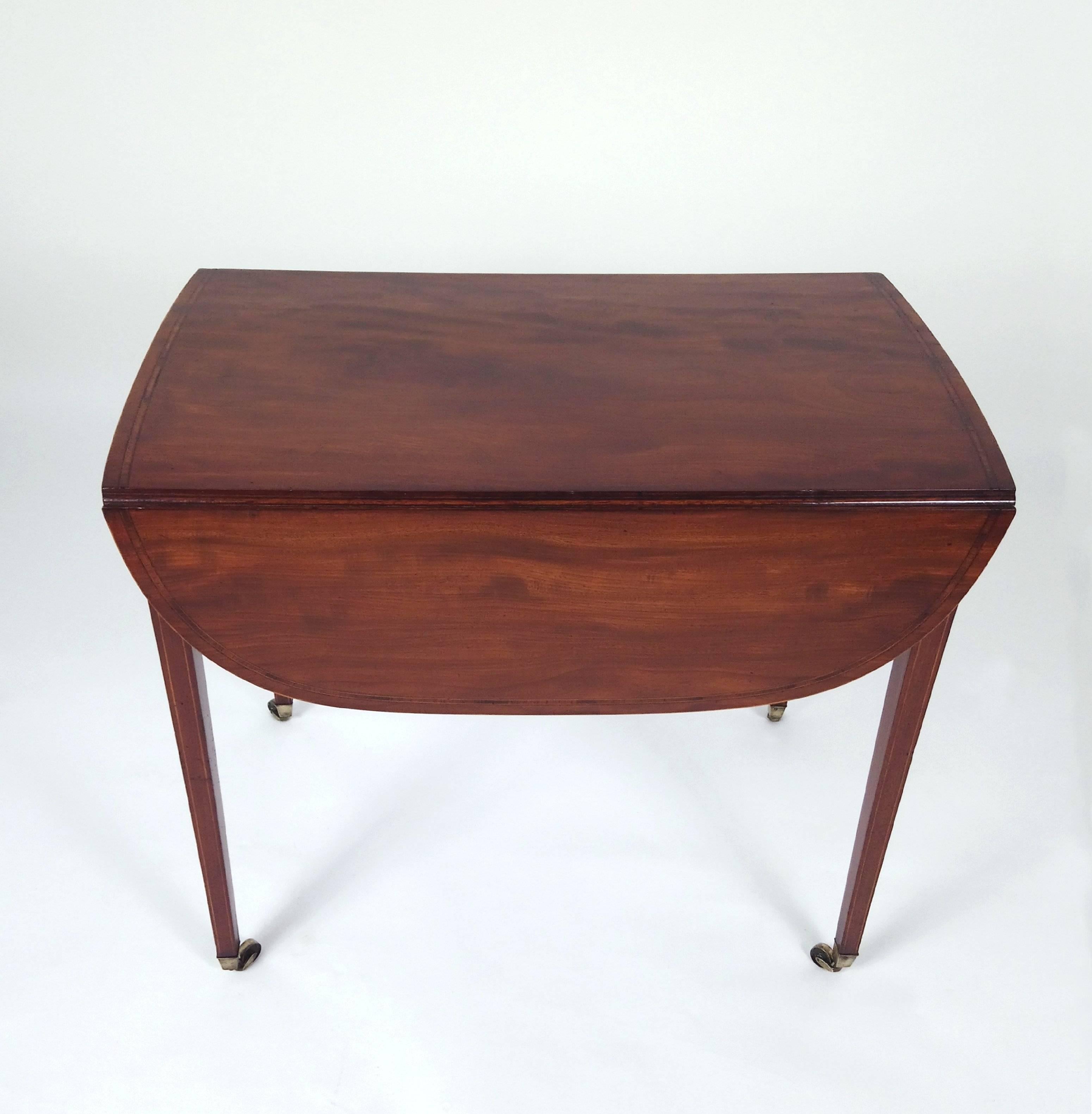 This very handsome and practical, 18th century. Sheraton design mahogany drop leaf Pembroke table features a crossbanded border around the tabletop as well as the drawers and inlaid diamond design decoration. The table has a drawer face on each