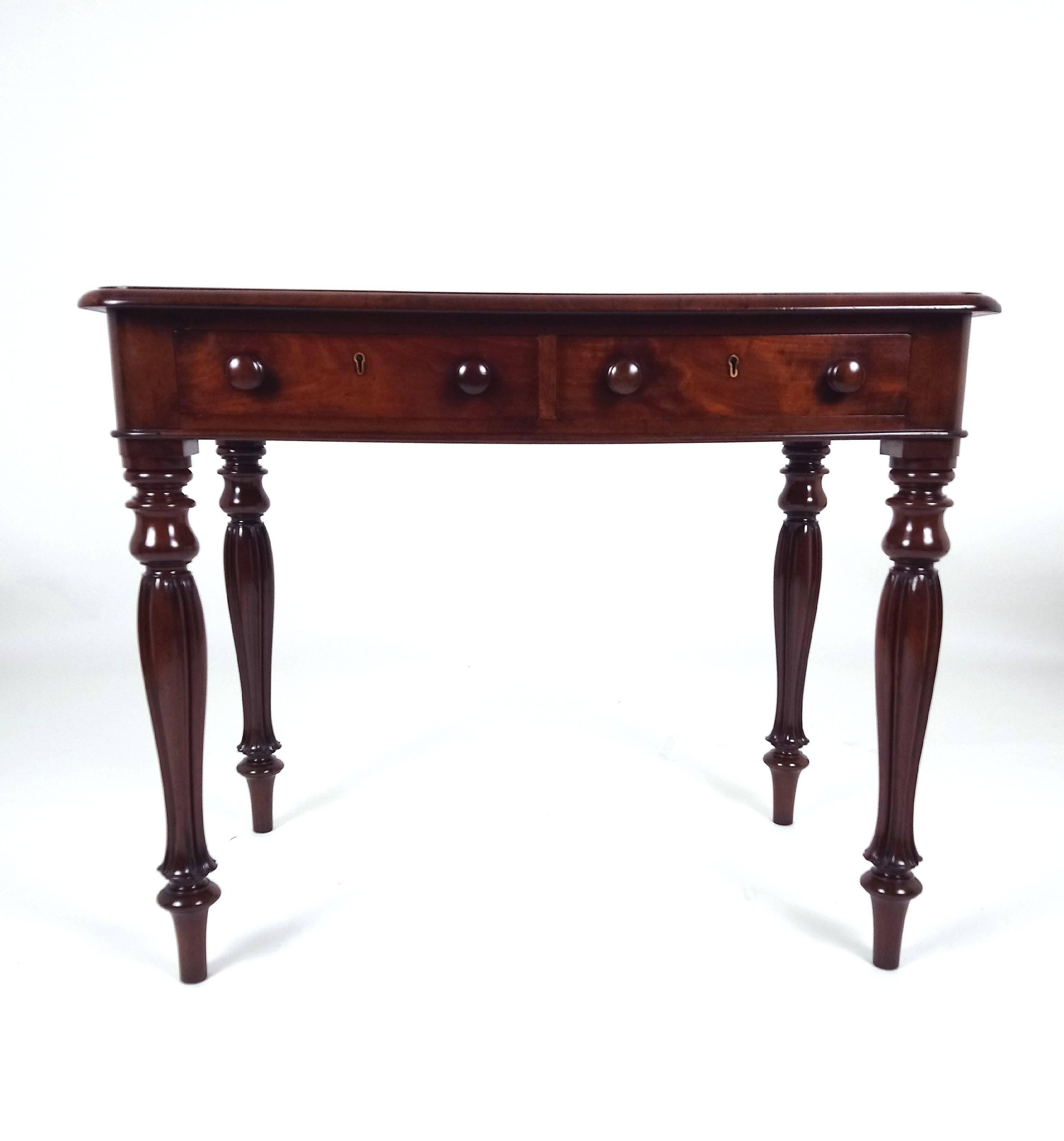This very attractive and good quality early Victorian mahogany center table features two drawers showing on each side, with two working drawers and two false drawers. The table stands on slender melon turned supports and has a rich, deep color. It
