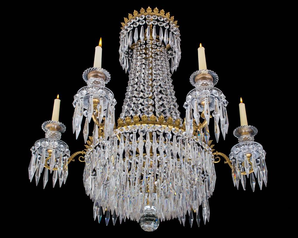 A fine Regency chandelier of Classic tent and waterfall design the main ring with fine decorative band issuing six arms supporting drop hung diamond cut drip pans and candle nozzles the top crown and main ring hung with triangular icicle drops the