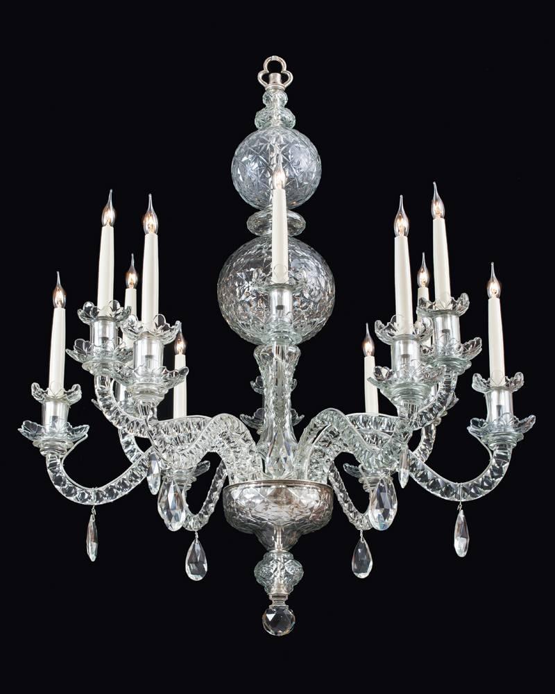 A fine pair of George II style twelve-light silvered mounted cut-glass chandeliers the main facet cut ball surmounted by smaller facet cut balls and collars. The receiver plate supporting twelve notched cut candle arms terminating with drip pans and