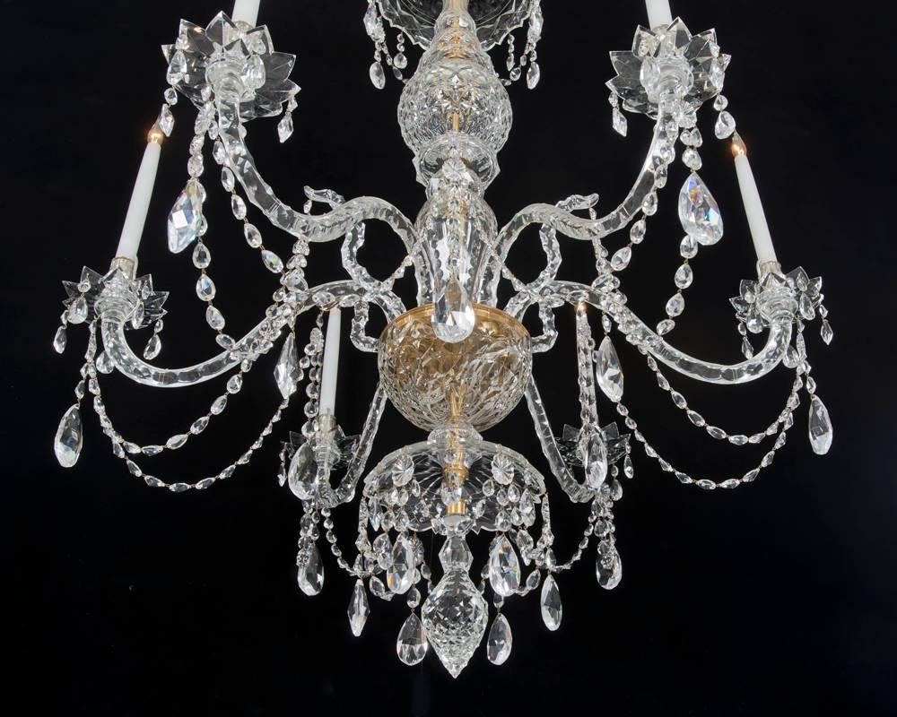 The baluster shaped shaft with drop hung canopy's the shaft terminating with a flat diamond cut finial. The receiver bowl surmounted with six slip over candle arms and six snake crook arms. the chandelier draped with chain and finial pear shaped