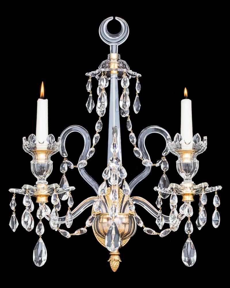A fine pair of English George III style two-light cut-glass and ormolu-mounted wall lights the central spire surmounted by van dyke canopy and moon crescent finial . The main container surmounting six sided candle arms and van dyke nozzles and drip