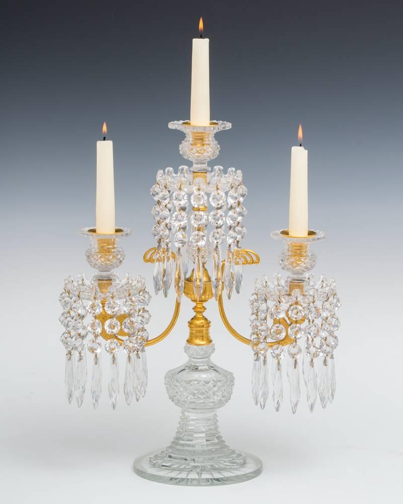 The diamond and step cut oval bases surmounted with ormolu twin branches these finely cast with winged cherubs. These supporting multi spike drip pans hung with round icicles and double pointed spangles the branches supporting diamond and step cut