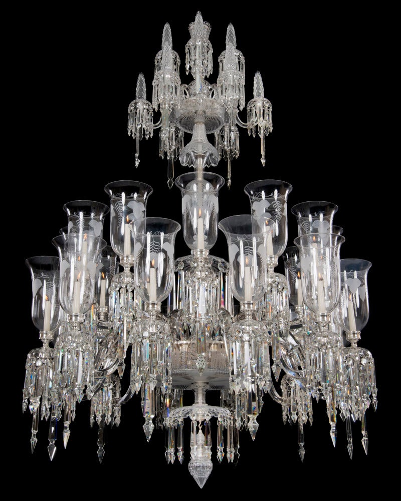 The cut crystal shaft of fountain form unusually engraved with anthemion the upper section with twelve scroll branches arranged on two levels these with scallop edged turnover canopies and pinecone finials. The main receiver bowl with under canopy