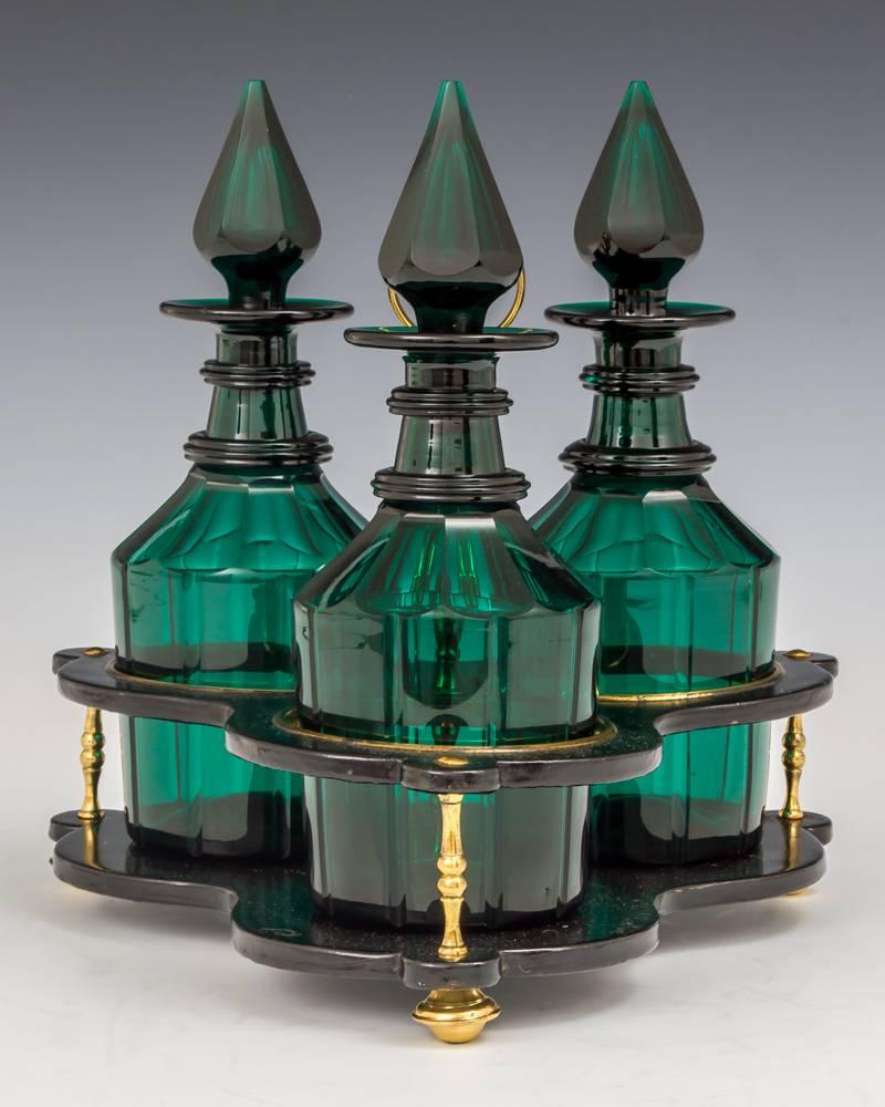 A fine set of three green decanters in black lacquered and brass fitted stand.
 
Decanters:
 
Height 9 1/2in (24cm),
 
width 3 1/2in (9cm).
 
Decanters in stand:
 
Height 10 1/2in (26.5cm),
 
width 10 1/4in (26cm).