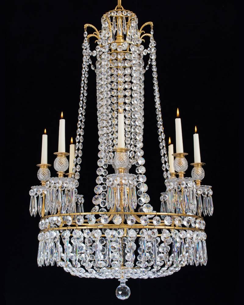 An important Regency period ormolu-mounted cut-glass eight-light chandelier by John Blades the main drop hung double band supporting scallop edged drip pans and diamond cut candle nozzles, the main shaft formed as a urn made up from granulated