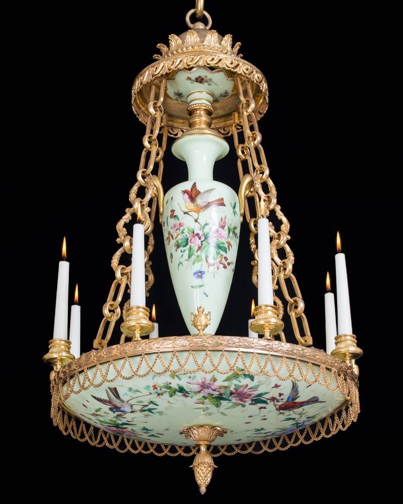 A highly unusual ormolu and opaque glass dish light the fine ormolu leaf band hung with swags of chain the band issuing eight candle nozzles and four ormolu urns this suspended from a scroll and leaf canopy on four chains. The top pan, central urn
