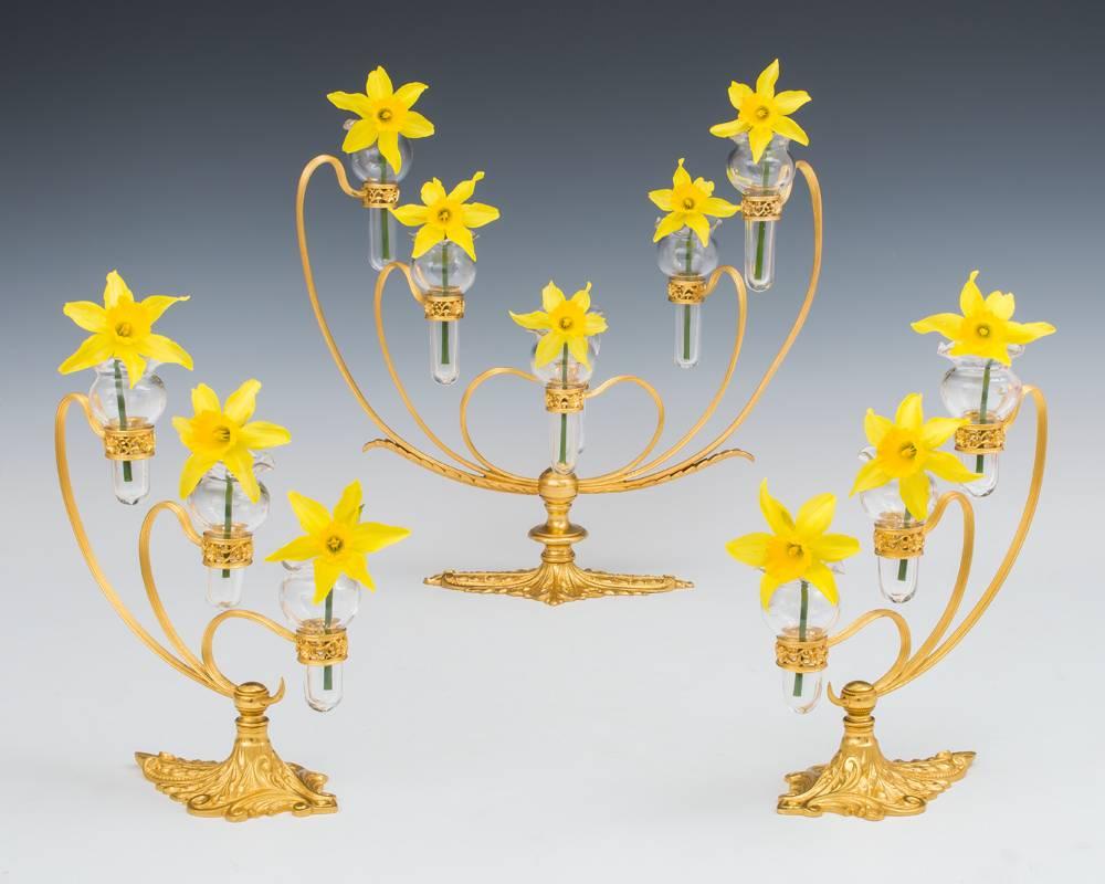 A stunning garniture by F&C Osler conspiring of a central ormolu base issuing six arms arranged over three levels mounting glass posy vases together with two smaller bases issuing three arms and vases the base stamped OSLER.
Measures:
Height: 13