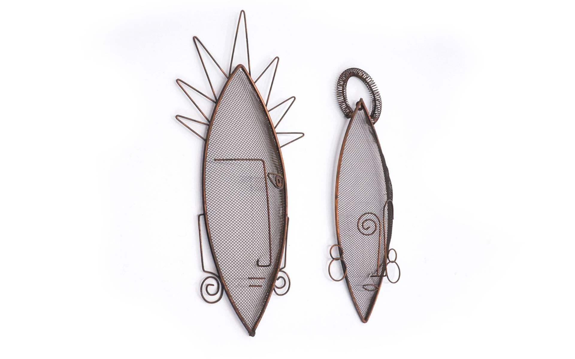 Very rare pair of wire mesh masks sculptures by Frederic Weinberg. Interesting African influence in the design.  
