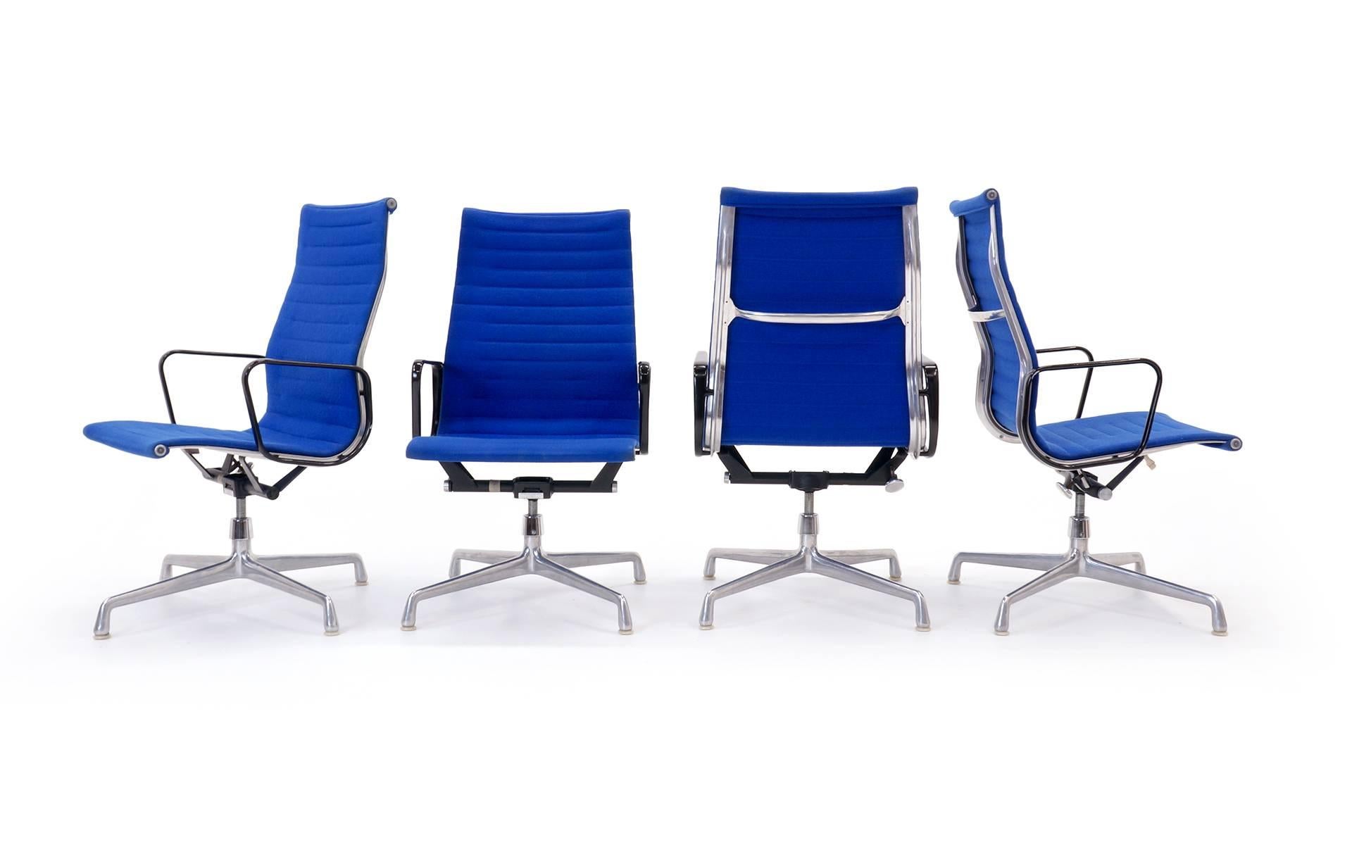 Sechs verfügbar. Eames for Herman Miller Aluminiumstühle mit hoher Rückenlehne und Armlehnen, die mit dem Originalstoff von Alexander Girard for Herman Miller bezogen sind. Die Stühle behalten ihre ursprünglichen Vier-Sterne-Guss-Aluminiumfüße.