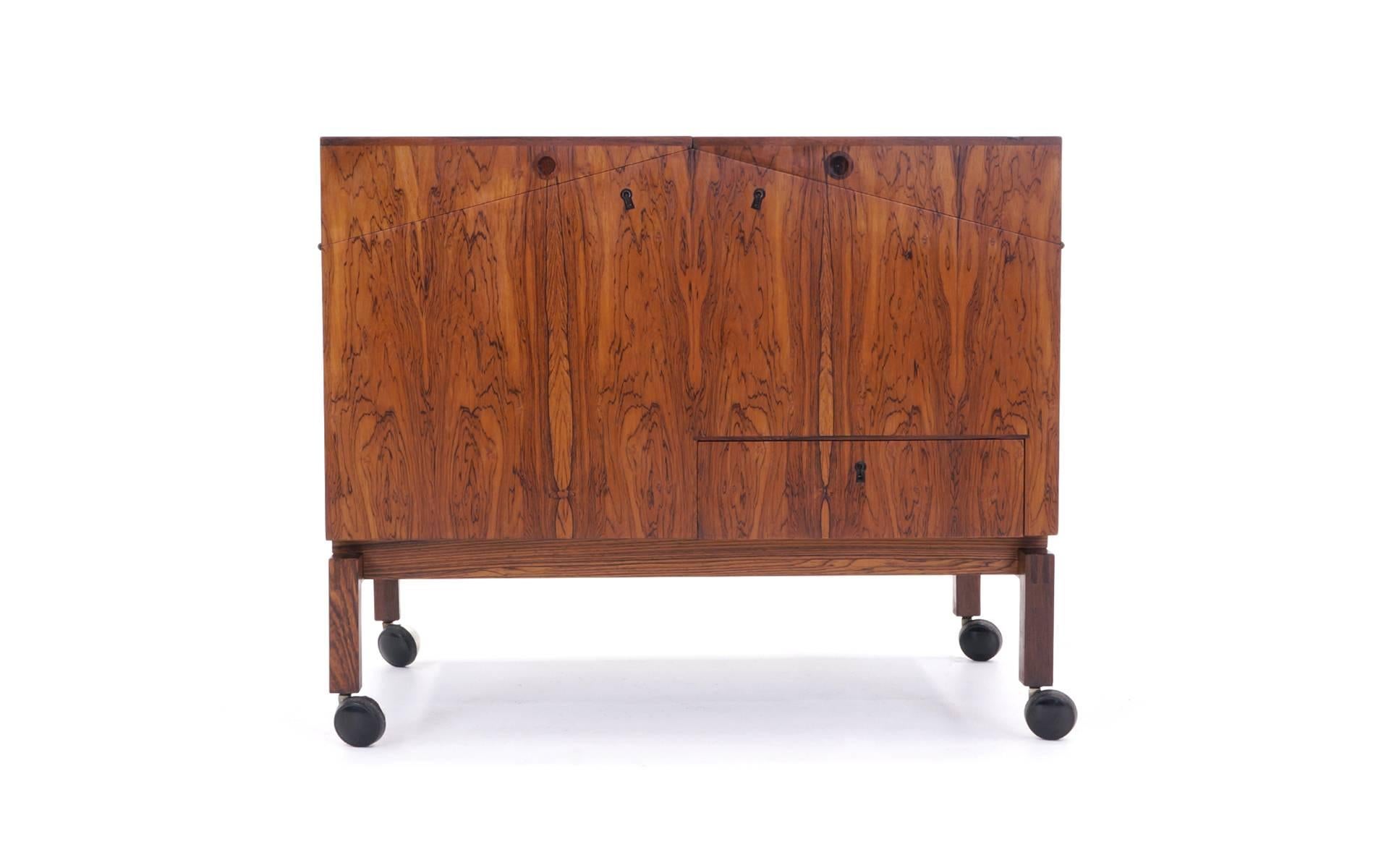 Beautiful Brazilian rosewood Danish modern bar cabinet designed by Leif Alring for C.F. Christensen, Denmark, 1964. Bar features one locking drawer and two locking flip-top doors concealing bottle storage and one removable tray. Dimensions are