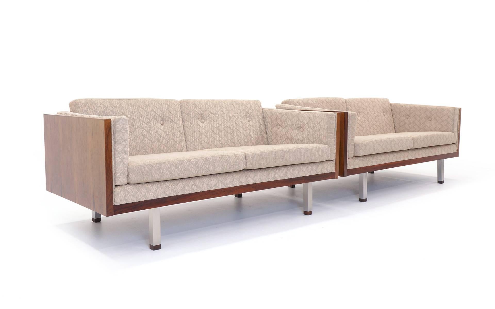 Matching pair of rosewood loveseats designed by Jydsk Møbelværk. Brushed steel legs with rosewood feet. Also see our listing for the matching chair.