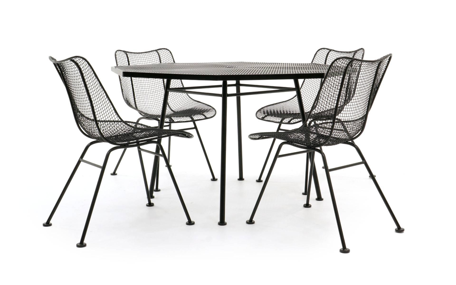Two octagonal Russell Woodard dining tables, each with four woven wire Sculptura armless dining chairs. Eight chairs total. Professionally media blasted and powder coated in a satin black. Never outdoors since restoration. Price is for both sets. We