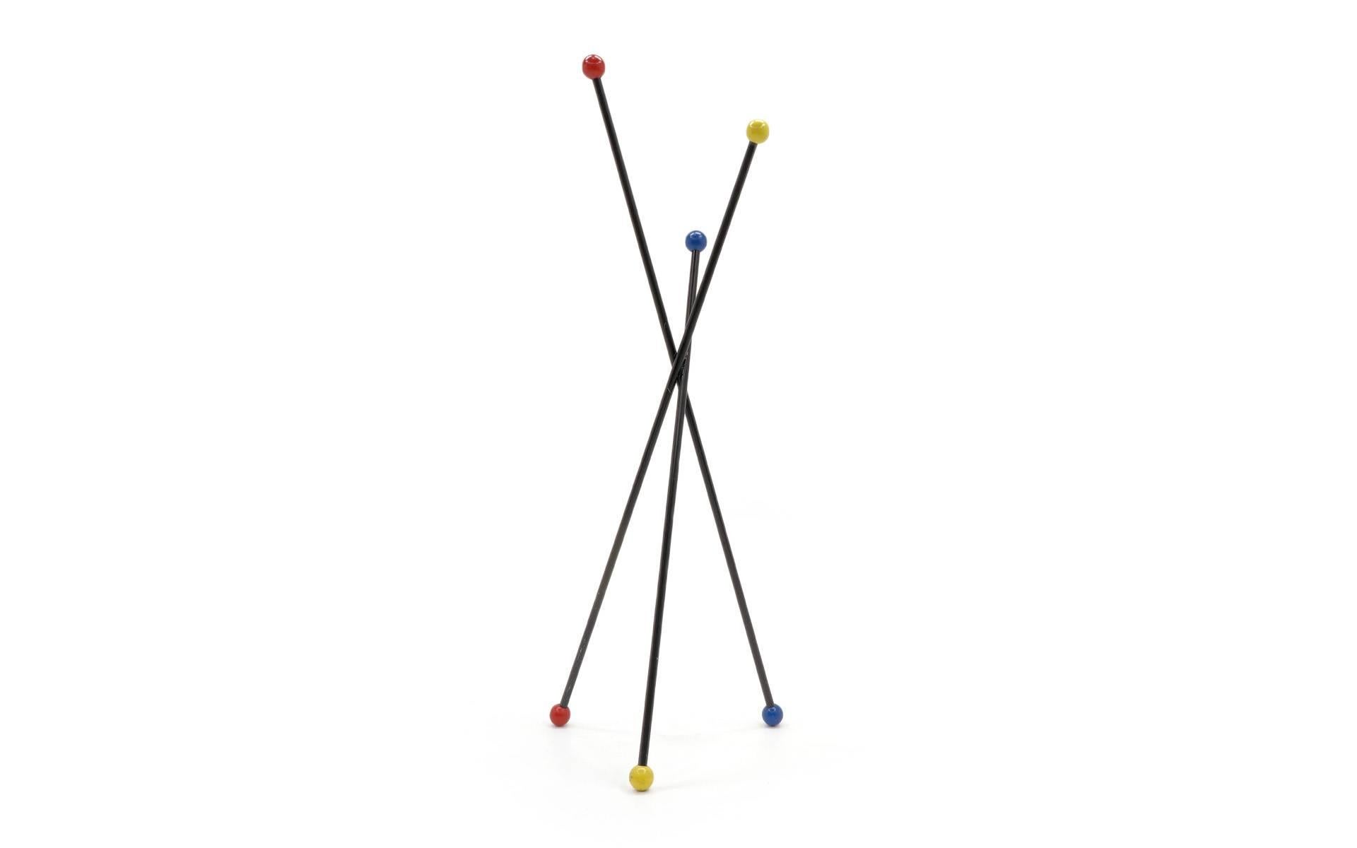 1950s French coat stand. Three enameled tubular steel rods in a crossing pattern with lacquered wood balls on each end.