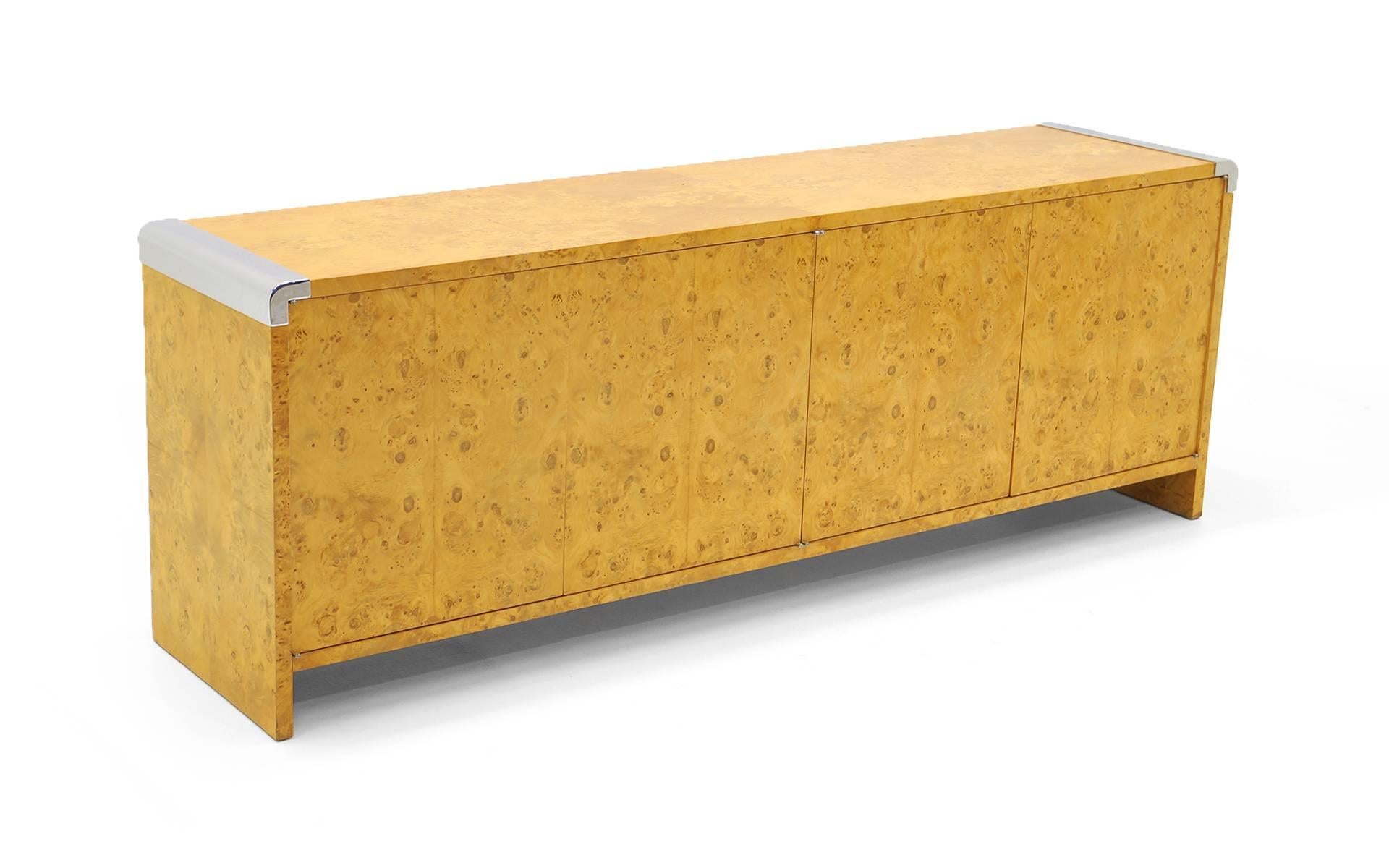 Milo Baughman for Thayer Coggin olive wood burl credenza or buffet with chrome accents on the top ends. Push open doors reveal adjustable shelves on ones side and drawers on the other.