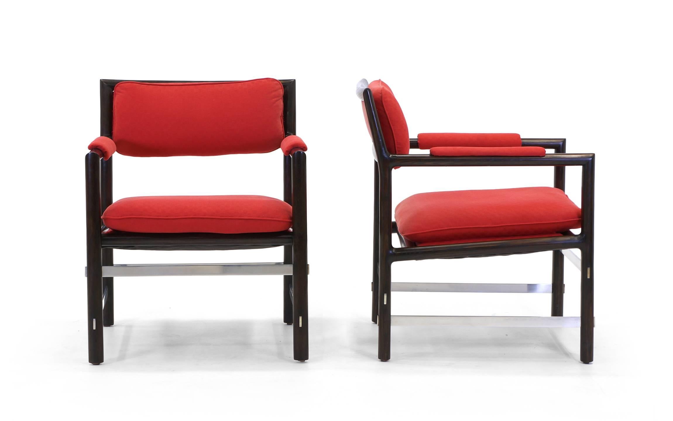 Stunning pair of Edward Wormley for Dunbar armchairs. Dark African mahogany frames with intersecting brushed steel cross stretchers. The red fabric is in very good condition. These chairs were reupholstered approximately five years ago.