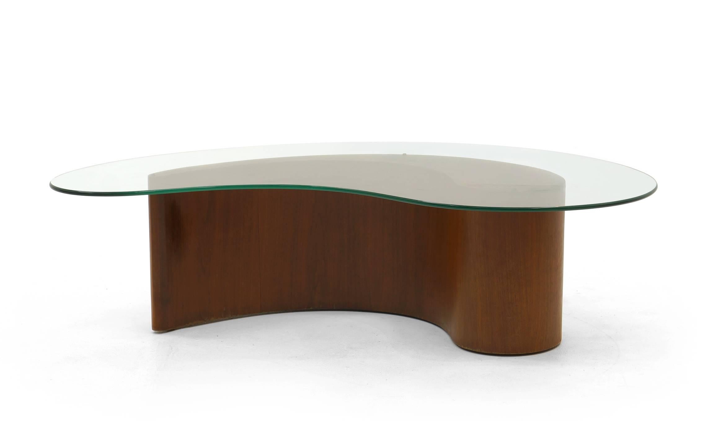 Vladimir Kagan for Selig biomorphic comma table, also referred to as the apostrophe table. Walnut base and original kidney shaped glass. We will be posting a Kagan cloud sofa in the near future that would be the perfect compliment to this table.