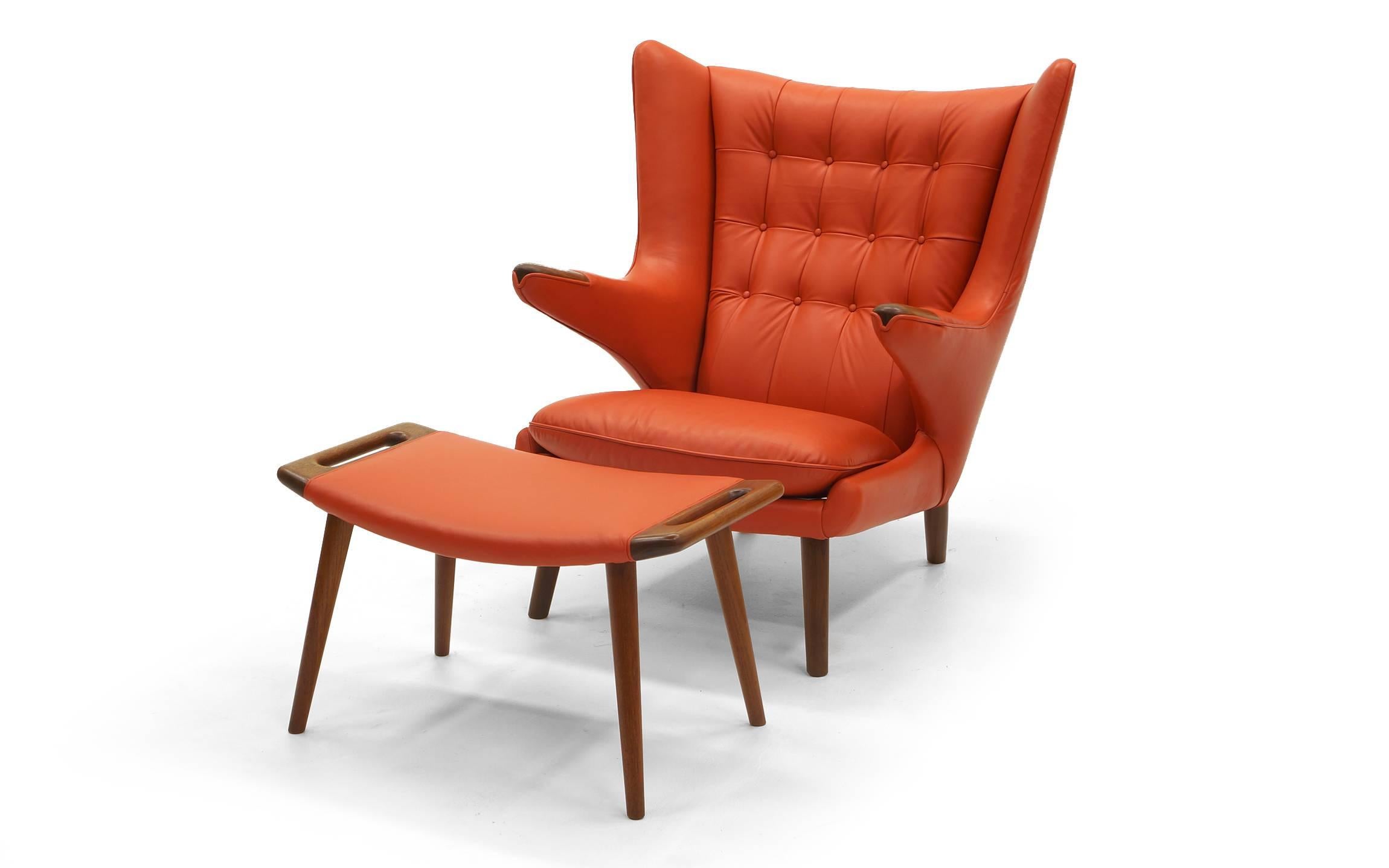 Pair of original Hans Wegner Papa Bear chairs with Ottomans made by A.P. Stolen, Denmark, circa 1950s. Expertly restored and reupholstered in orange spinney beck leather. One ottoman is stamped A.P. Stolen, Copenhagan, Designer Hans Wegner. Chairs