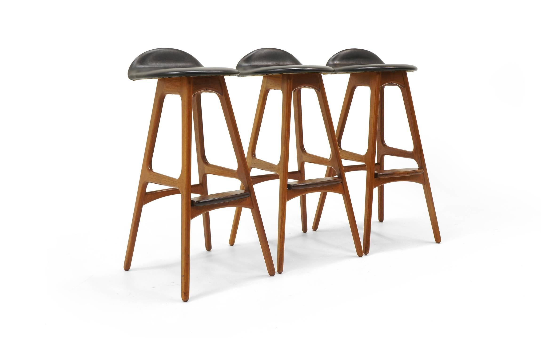 Three Erik Buch Danish modern barstools. Teak frames and rosewood footrests with original black leather seats. 30 inch seat height. Seat back is 33 inches high. The price is per stool. Buy one, two, or all three.