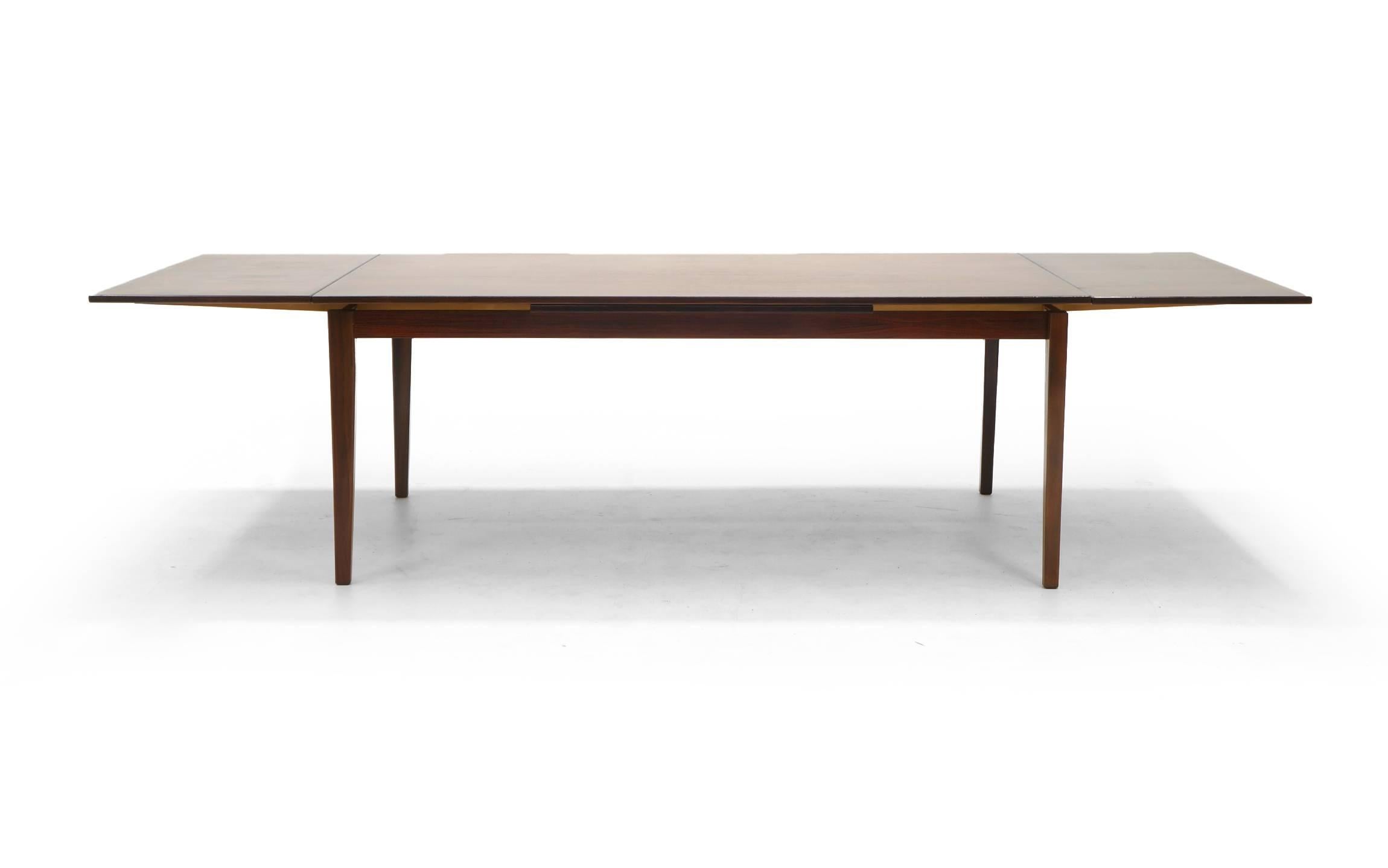 Brazilian rosewood Danish modern dining table. Table length measure is 73 inches with pull-out leaves on each end which are 20.5 inches each making the table expand to nine feet six inches. Table depth measure is 42 inches and height is 28.5 inches.