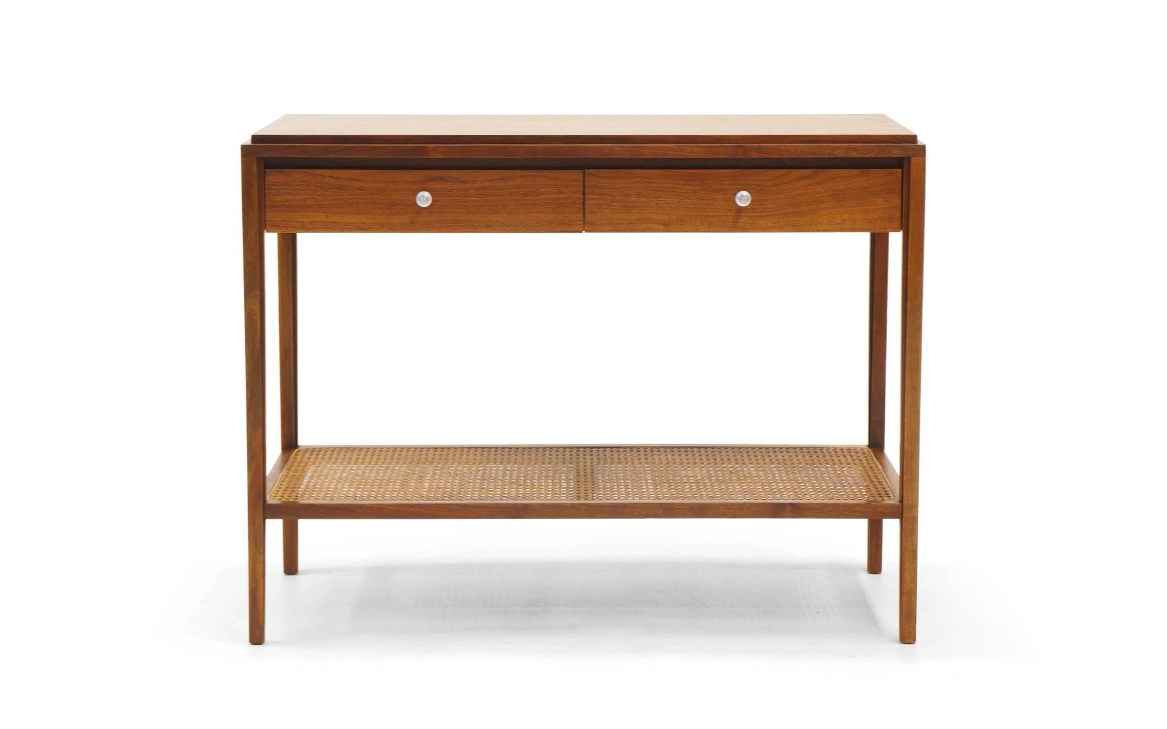Console designed by Paul McCobb for the Grand Rapids collection in walnut and cane featuring two drawers. Signed with applied fabric manufacturer's mark to drawer: [Widdicomb Grand Rapids].